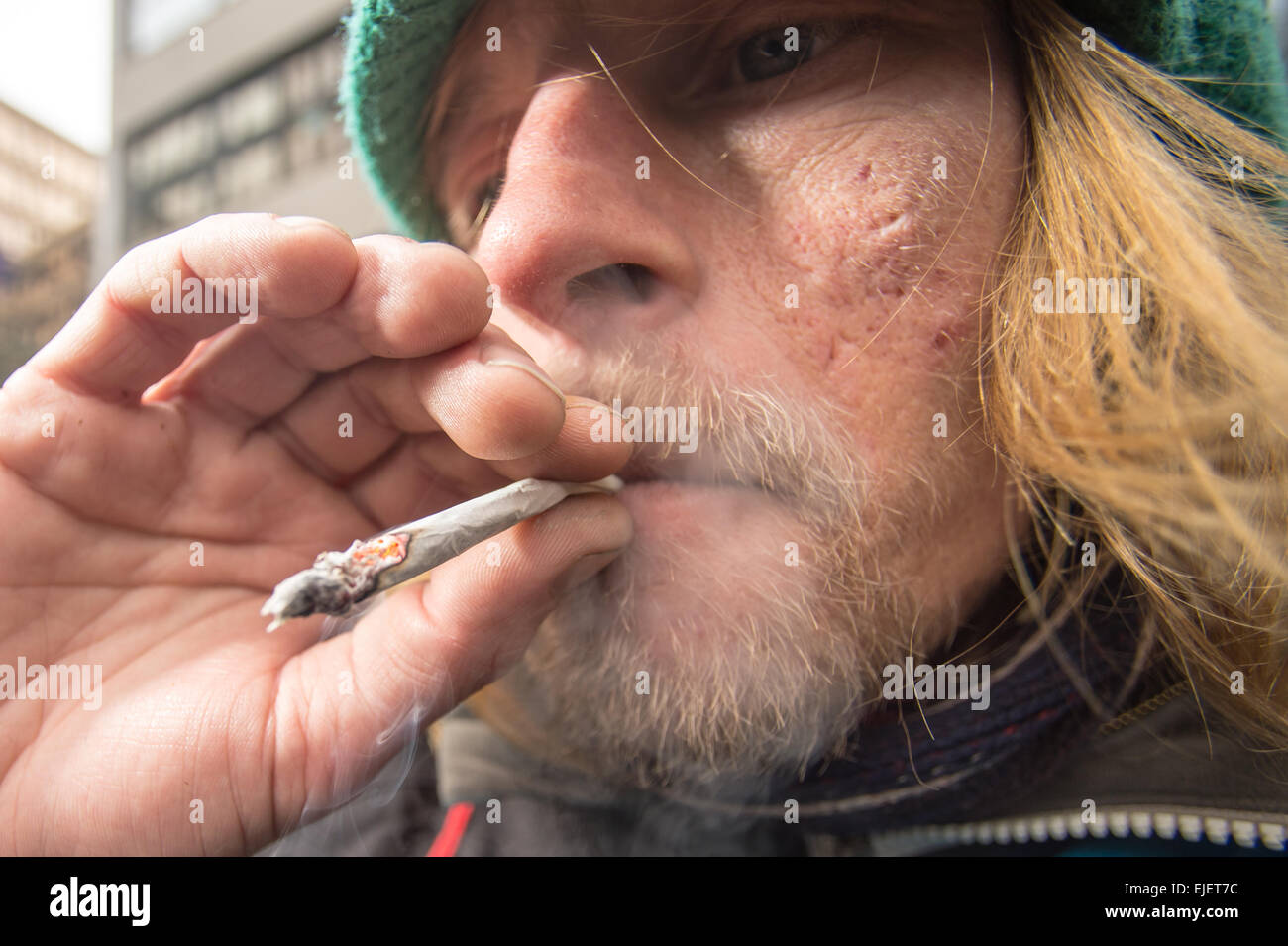 Ein Mann, der ein Joint mit Gewürz raucht, ein legaler High Stockfoto