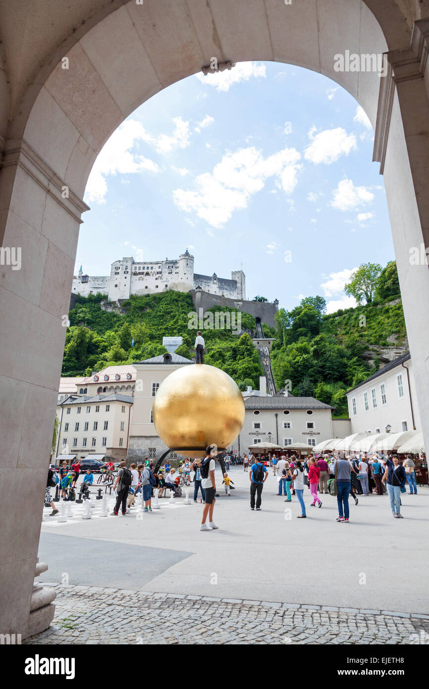 30 Fuß hohen gelben Ball Kugel Skulptur am Kapitelplatz Square mit Festung Hohensalzburg im Hintergrund Österreich Stockfoto