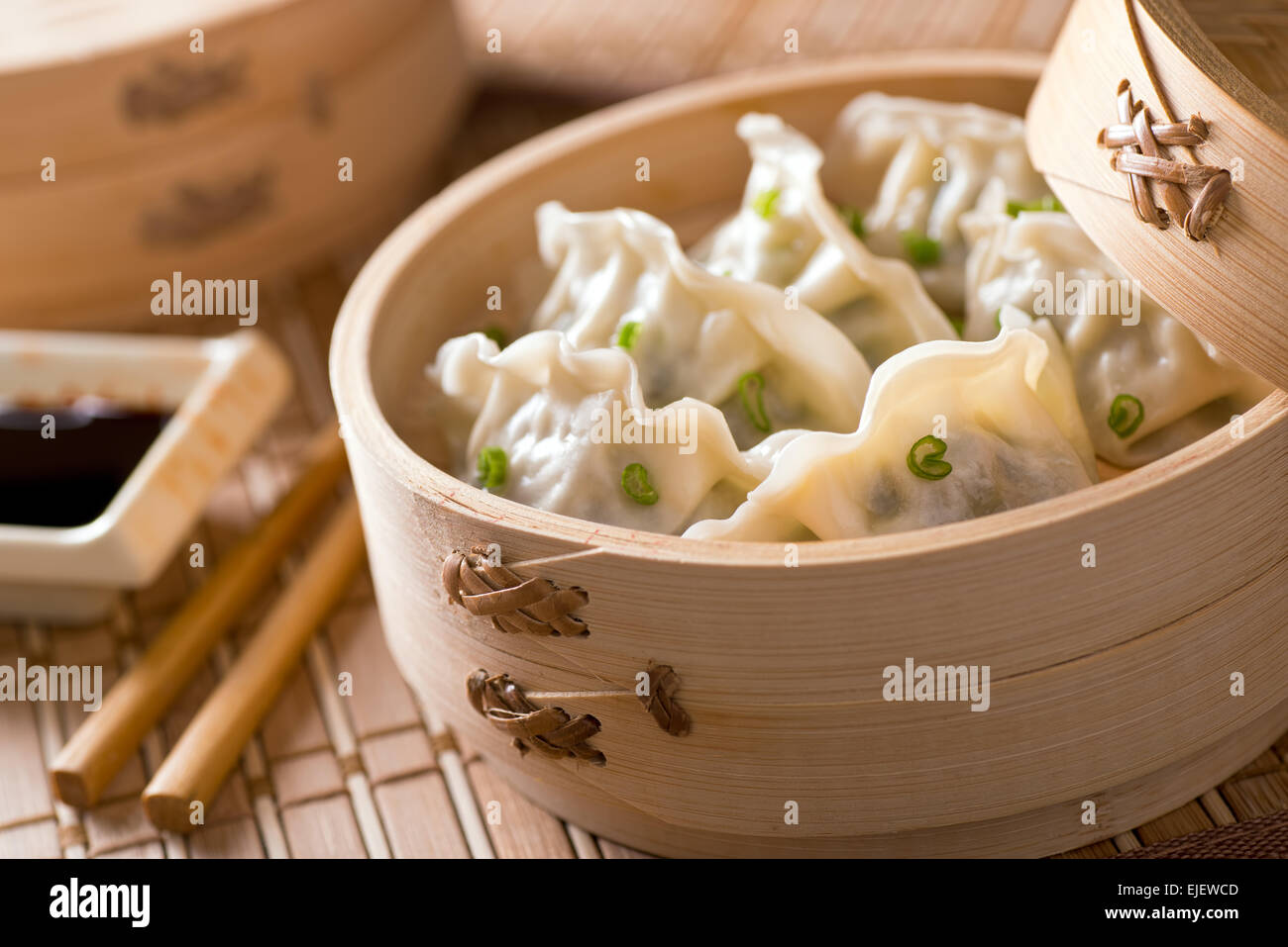 Dim Sum mit Lauch, Fleisch und Frühlingszwiebeln in einem Bambus-Dampfer. Stockfoto