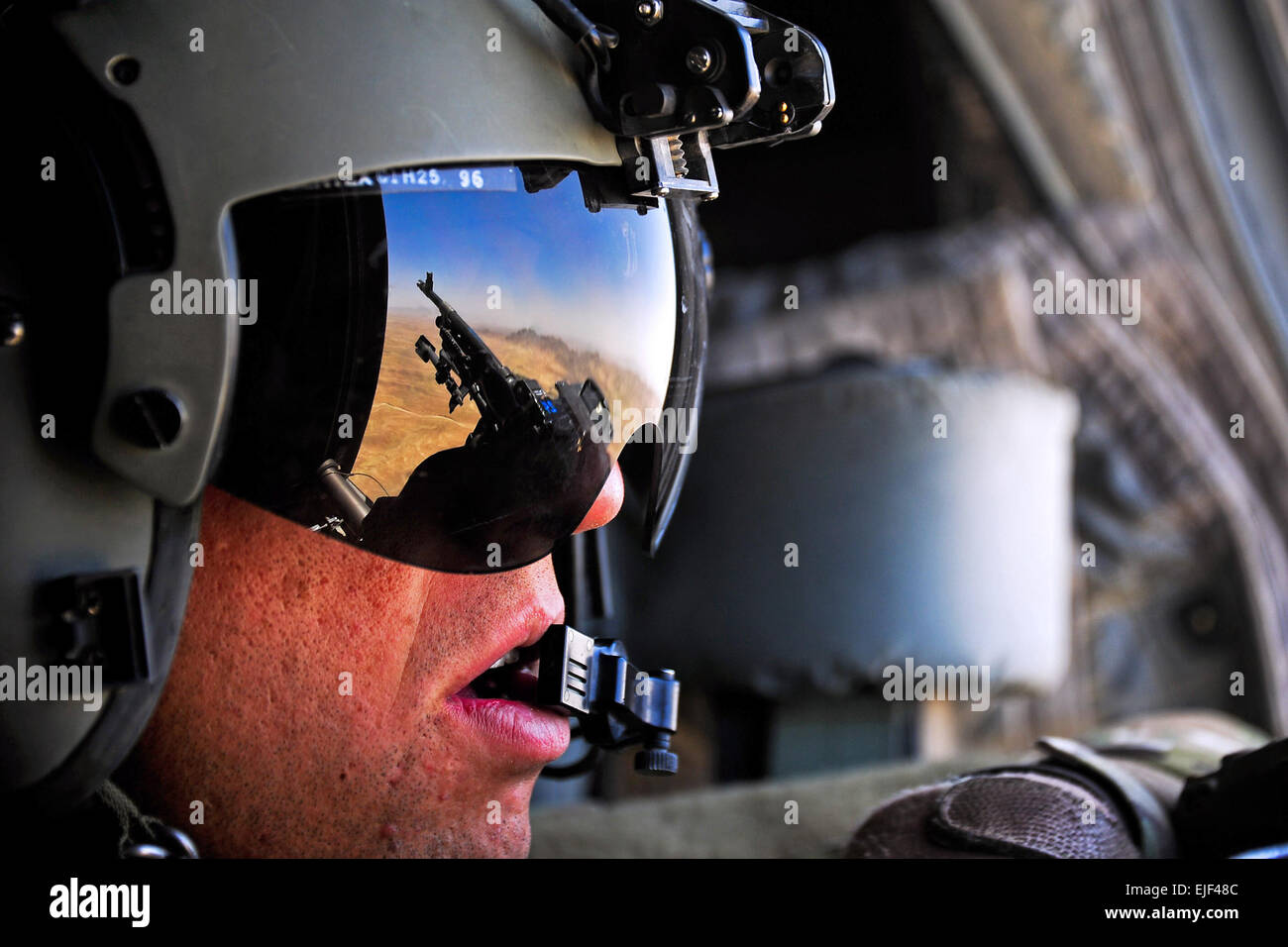 Ein US Army Crewchief mans seine Waffe und Sicherheit bietet, da er Transport hilft eine Schlinge geladen M777A2 Haubitze aus Deh Rawud Dorf in der Provinz Uruzgan, Kandahar Flugplatz in Afghanistan 18. Juni 2013.  CPL. Chris Moore Stockfoto