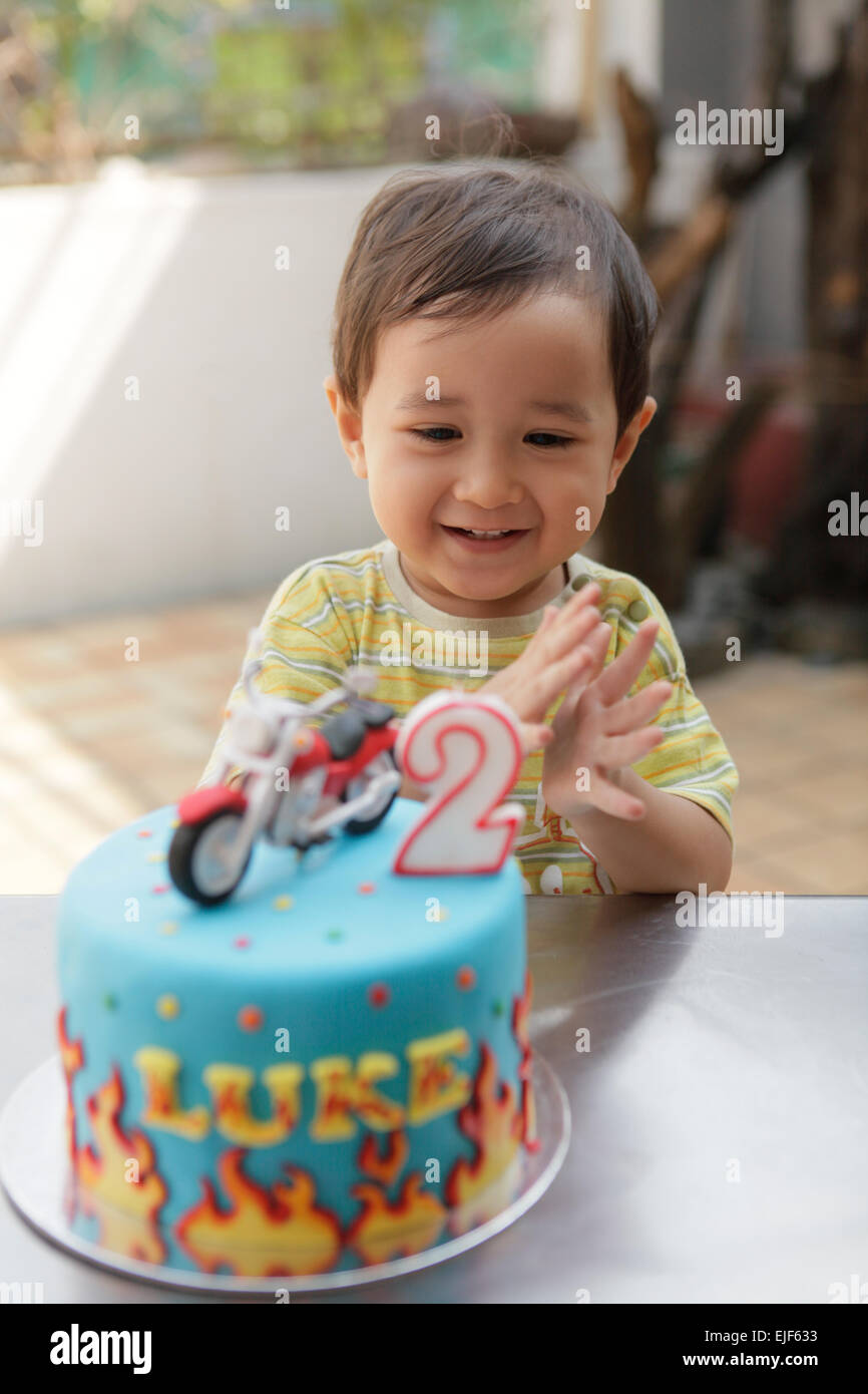 Hocherfreut Kleinkind Jungen klatschte nach Ausblasen der Kerzen auf seine Geburtstagstorte Stockfoto