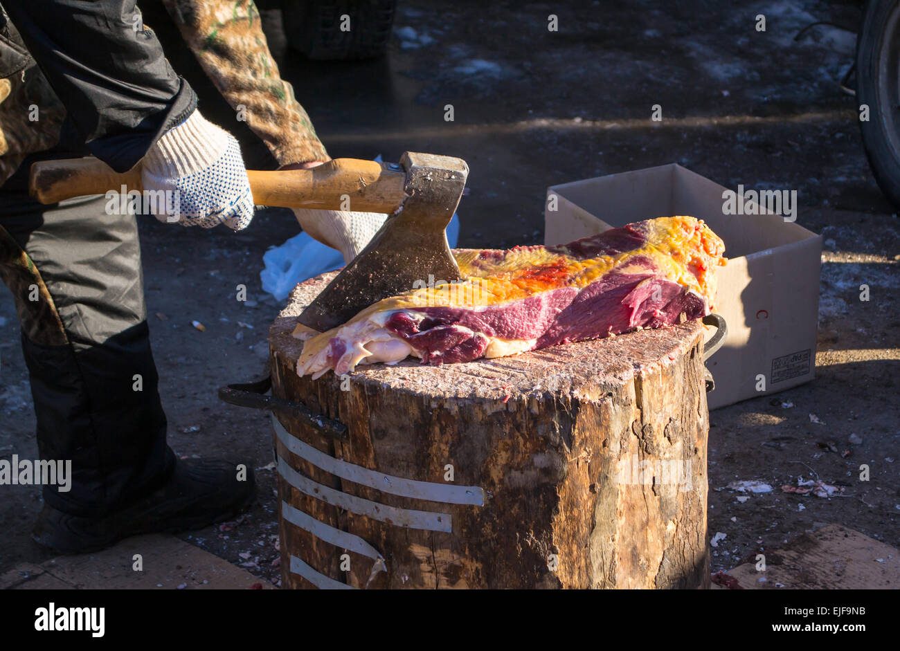 Ein Metzger verwendet eine Axt, frisches rohes Rindfleisch, die bereit sind, auf einem lokalen Markt verkaufen zu schneiden Stockfoto