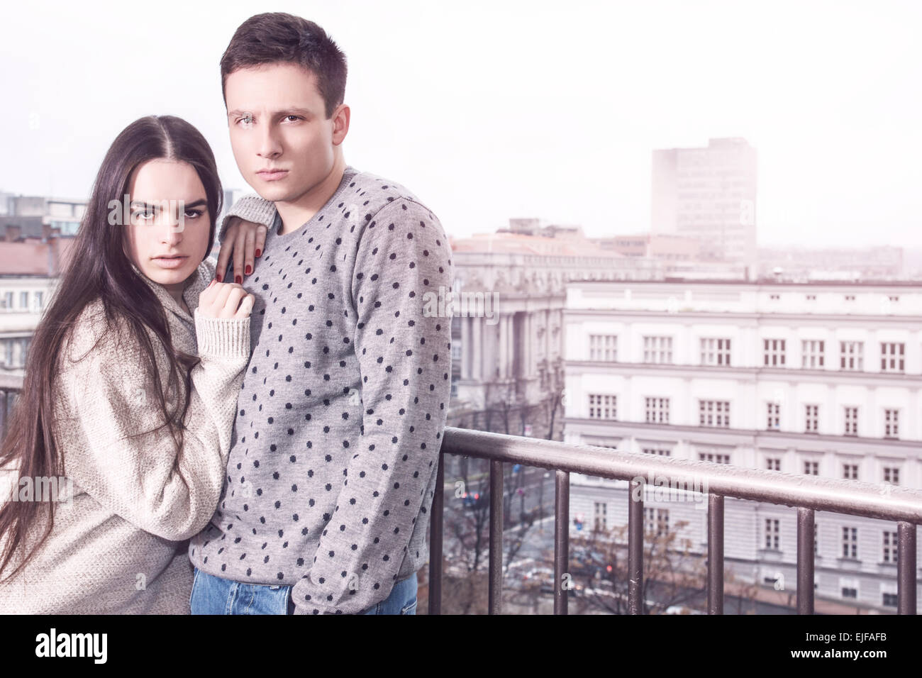 Süße junge Paar in Liebe auf Balkon Terrasse posiert, Stadtstraße im Hintergrund. Retro Vintage Lifestyle Modefoto Stockfoto