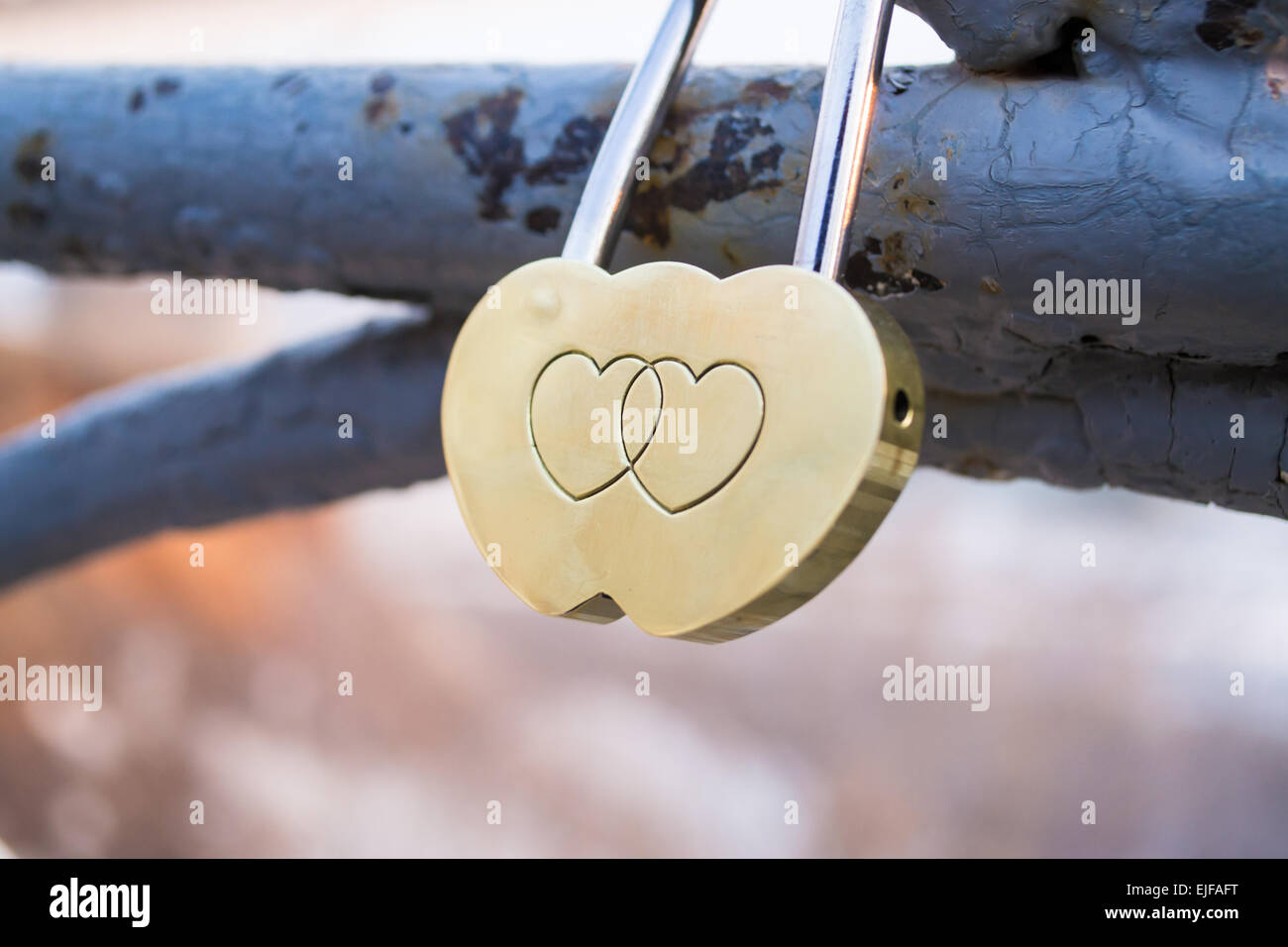 Zwei Herzen vereint auf einer goldenen herzförmigen Schloss