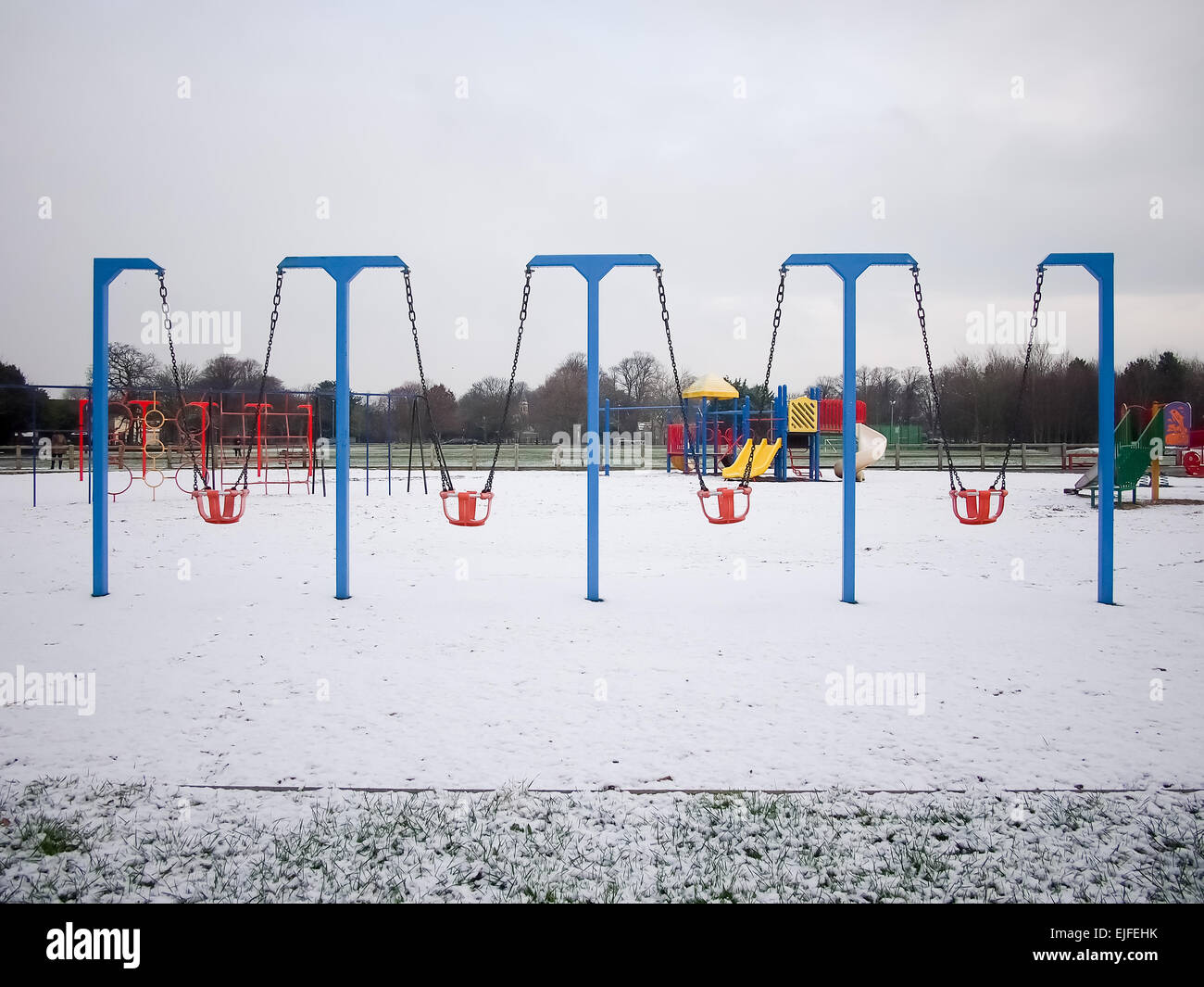 Schaukeln in einer leeren Kinder Spielplatz mit Schnee bedeckt Stockfoto