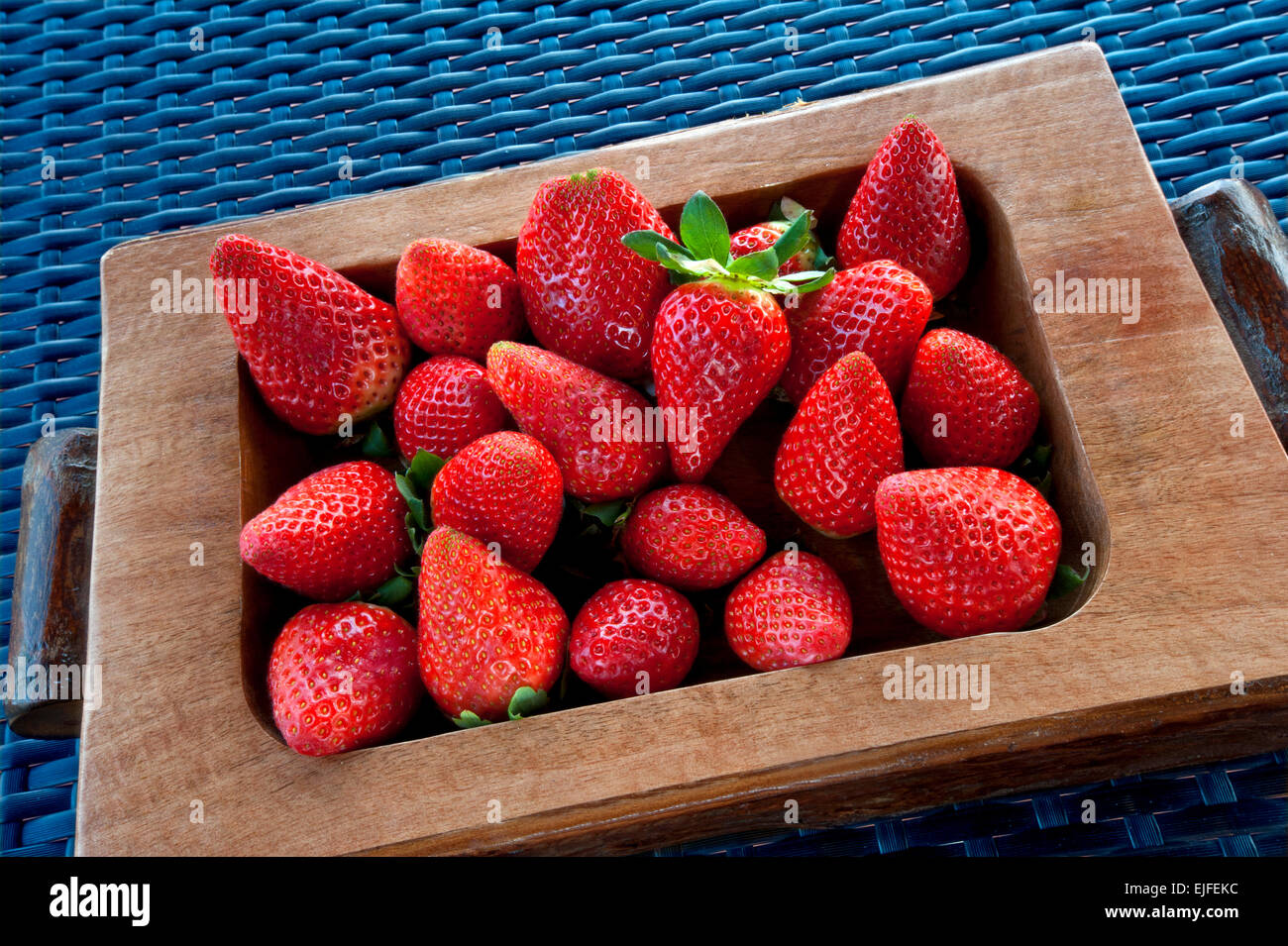 Frisch gepflückt reife Erdbeeren in Holztablett auf alfresco Küche Oberfläche Stockfoto