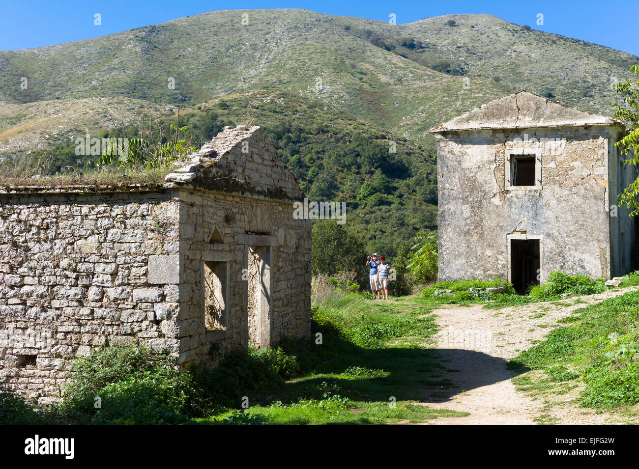 Touristen Steinhäuser-Ansicht verlassene alte Ruinen in alten Bergdorf von Old Perithia - Palea Peritheia - Korfu, Griechenland Stockfoto