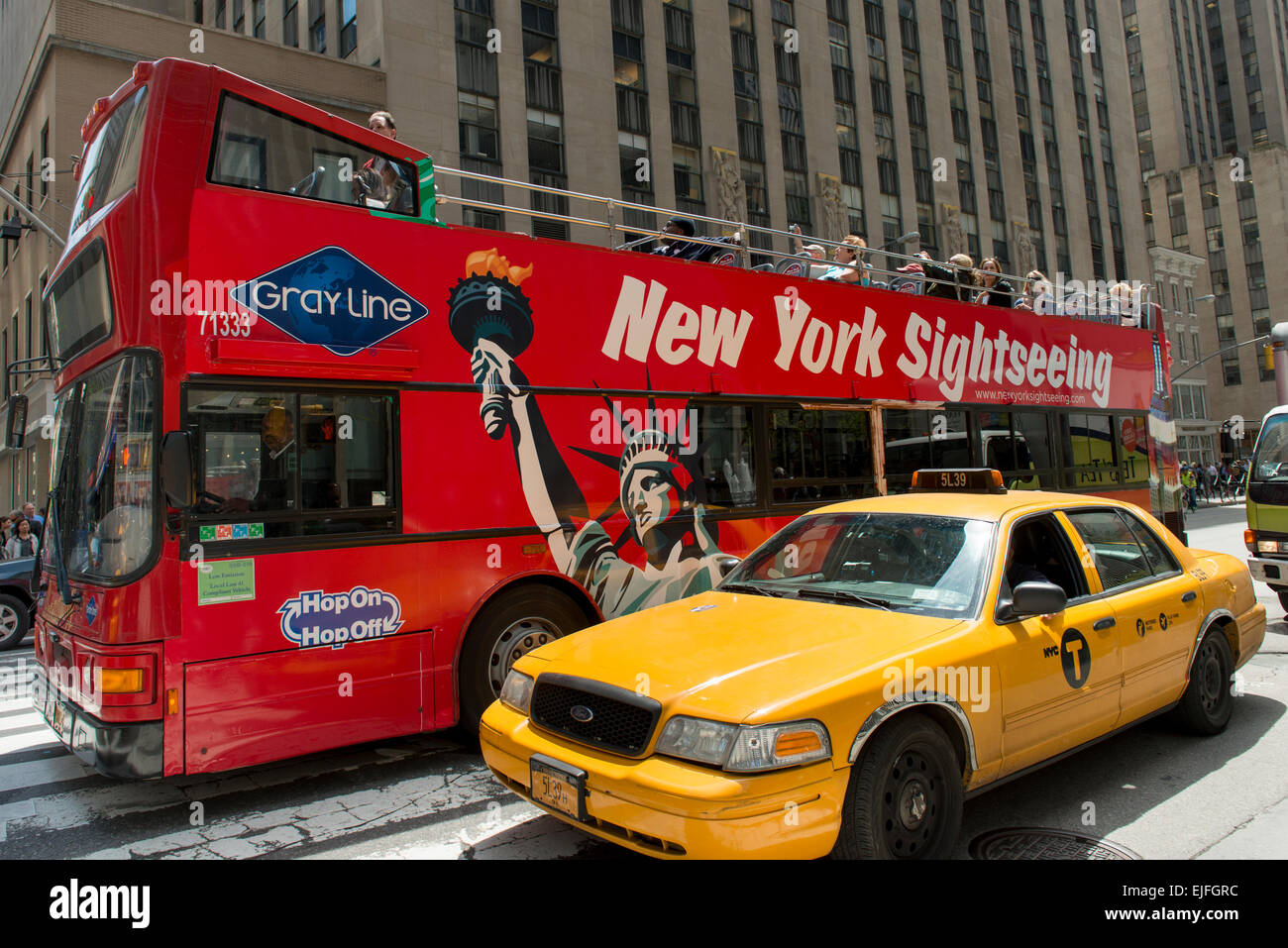 Gelbes Taxi mit Tourbus in Midtown Manhattan, New York City, New York State, USA Stockfoto