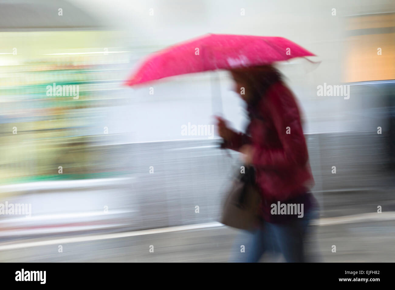 Person zu Fuß mit Regenschirm in regnerischen Tageslichtszene in Kerkyra, Korfu, Griechenland Stockfoto