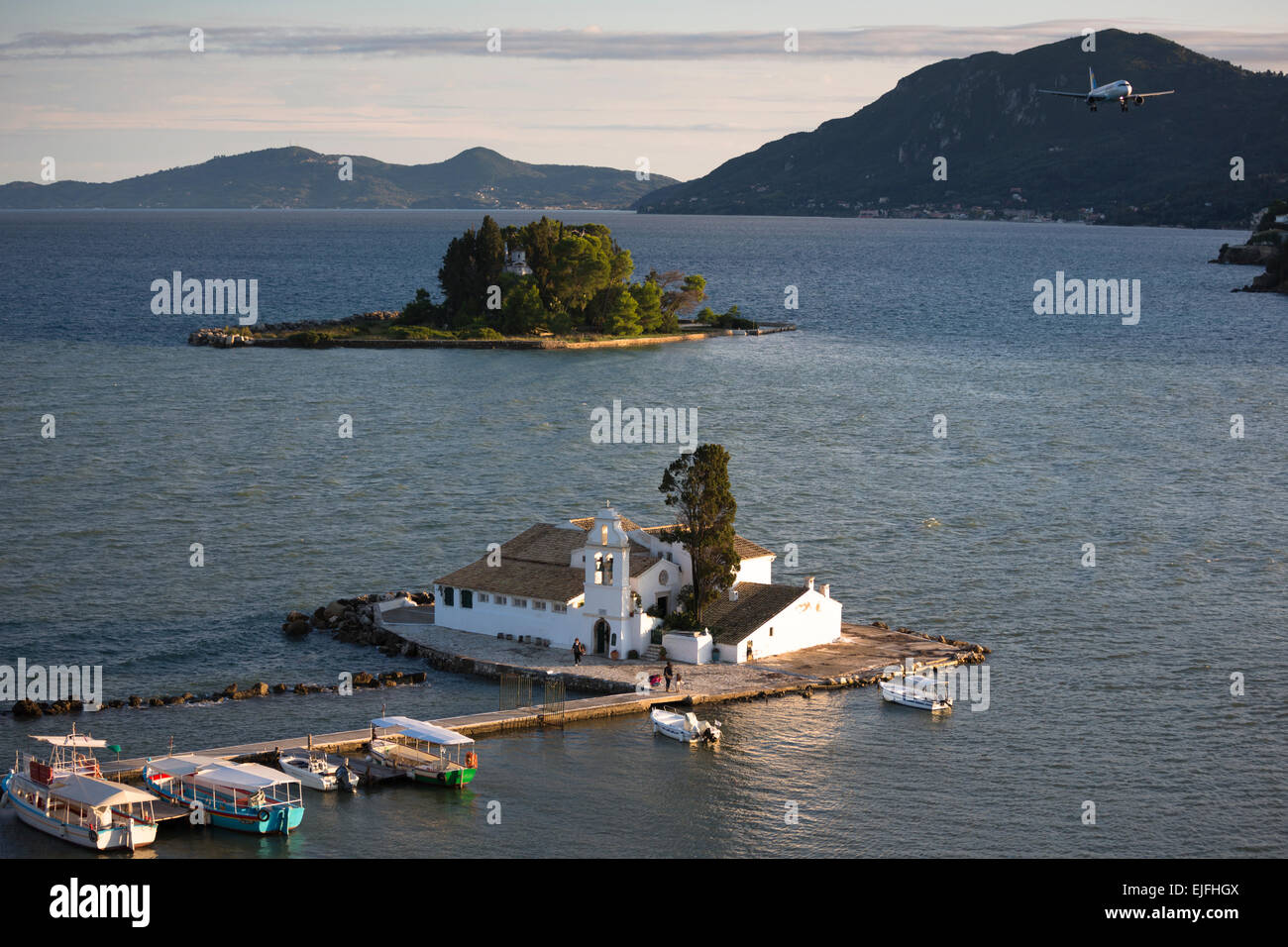 Flugzeug fliegen über berühmte Kloster Panagia Vlahernon vor Kanoni-Halbinsel in Kerkyra, Korfu, Ionische Inseln, Griechenland Stockfoto