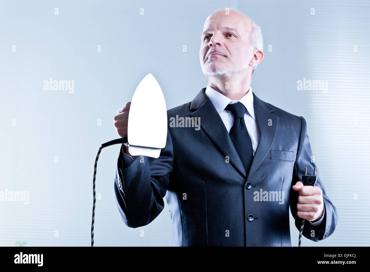 Business-Mann halten und ein Bügeleisen in der Hand steigt Stockfoto