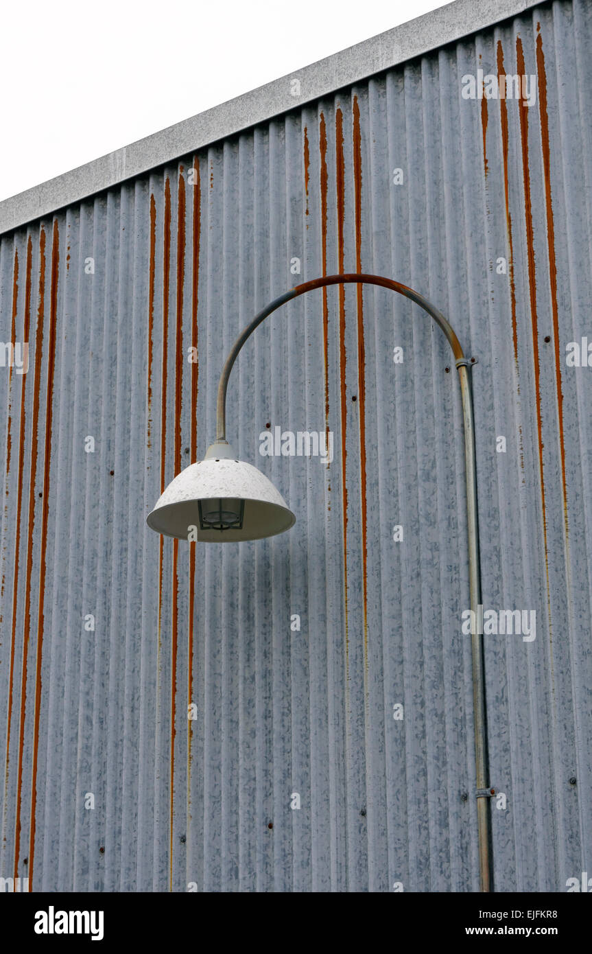 Gebogenen Metall Straßenlaterne an der Wellpappe Metall Wand eines Gebäudes befestigt Stockfoto