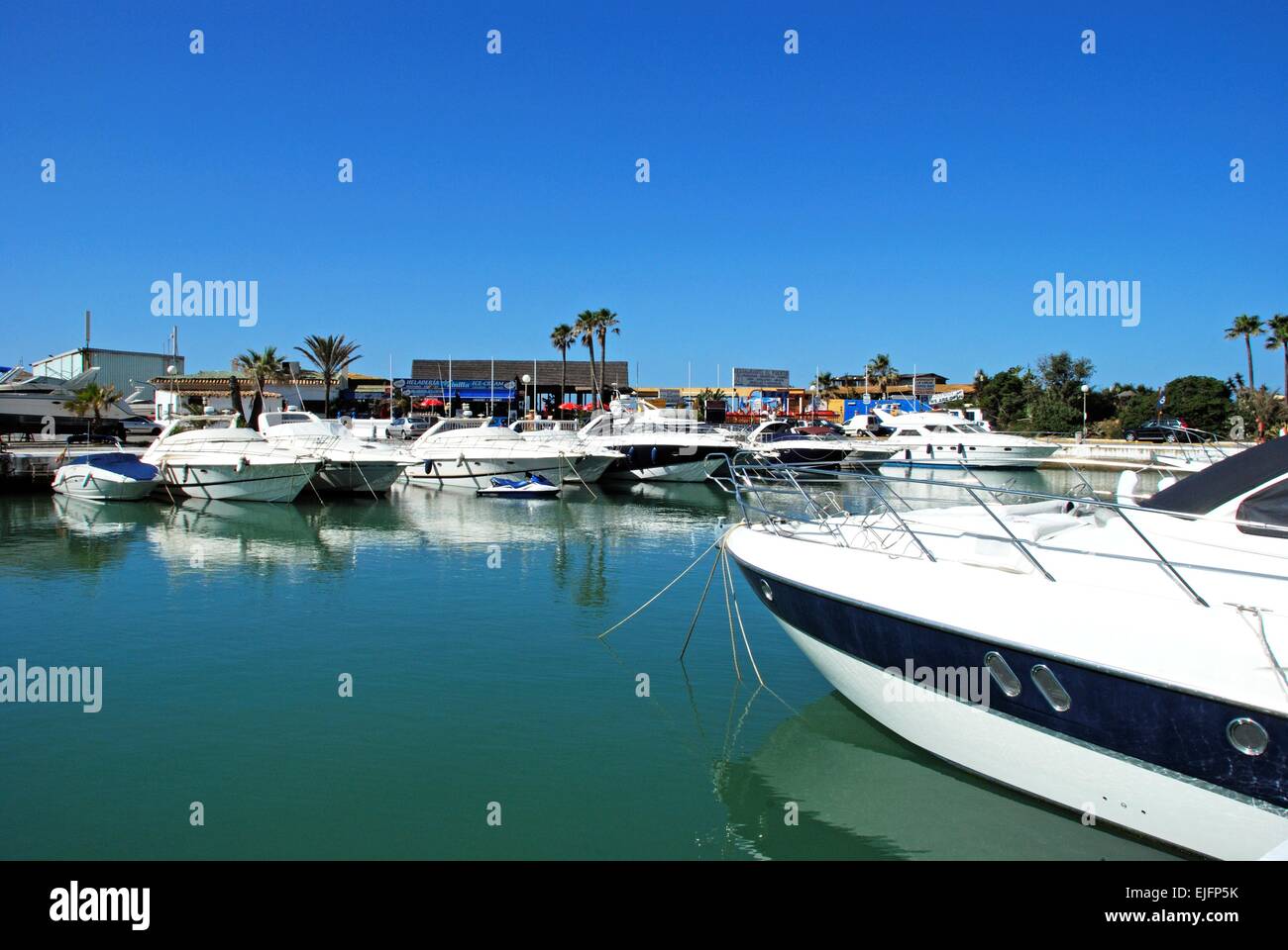 Boote im Innenhafen mit Restaurants nach hinten, Puerto Cabopino, Costa Del Sol, Provinz Malaga, Andalusien, Spanien. Stockfoto