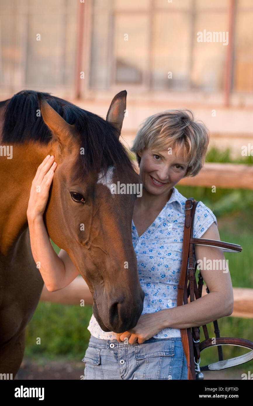 Frau in Hut Umarmung braunen Pferd. Close-up portrate Stockfoto