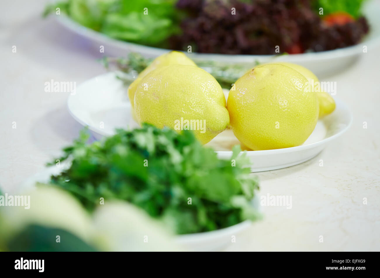 Zitronen, frische Kräuter auf einem Teller Stockfoto
