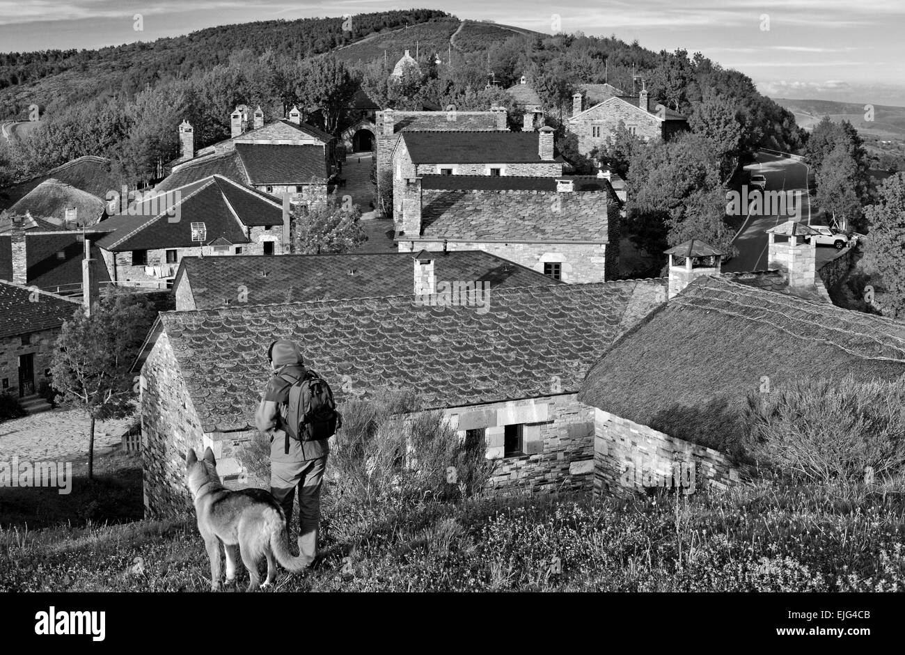 Spanien, Galicien: Pilger und Hund auf einem Hügel mit Blick auf St. James Way Bergdorf O Cebreiro in schwarz / weiß-version Stockfoto