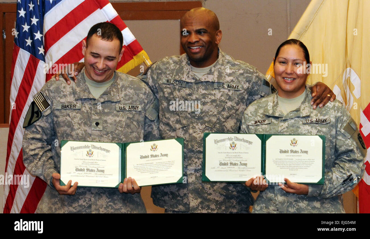 Paare Spc. Samuel Baker, ein Kommunikationssystem unterstützen Fach- und Pittsburgh native und Sgt. Raquel Baker, eine automatisierte Logistik-Spezialist und Temple, Texas heimisch, beide mit Headquarters und Headquarters Company, 15. spezielle Truppen Bataillon, 15. Sustainment Brigade, 13. Sustainment Command Expeditionary Pose mit Major Anthony Wilson, 15. STB Ausbildungsleiter, nach reenlisting zusammen hier 17 März.  Staff Sgt Matthew C. Cooley, heiratete 15. Sustainment Brigade Öffentlichkeitsarbeit Armee paar Reenlists zusammen /-news/2010/03/29/36536-army-married-couple-reenlist Stockfoto