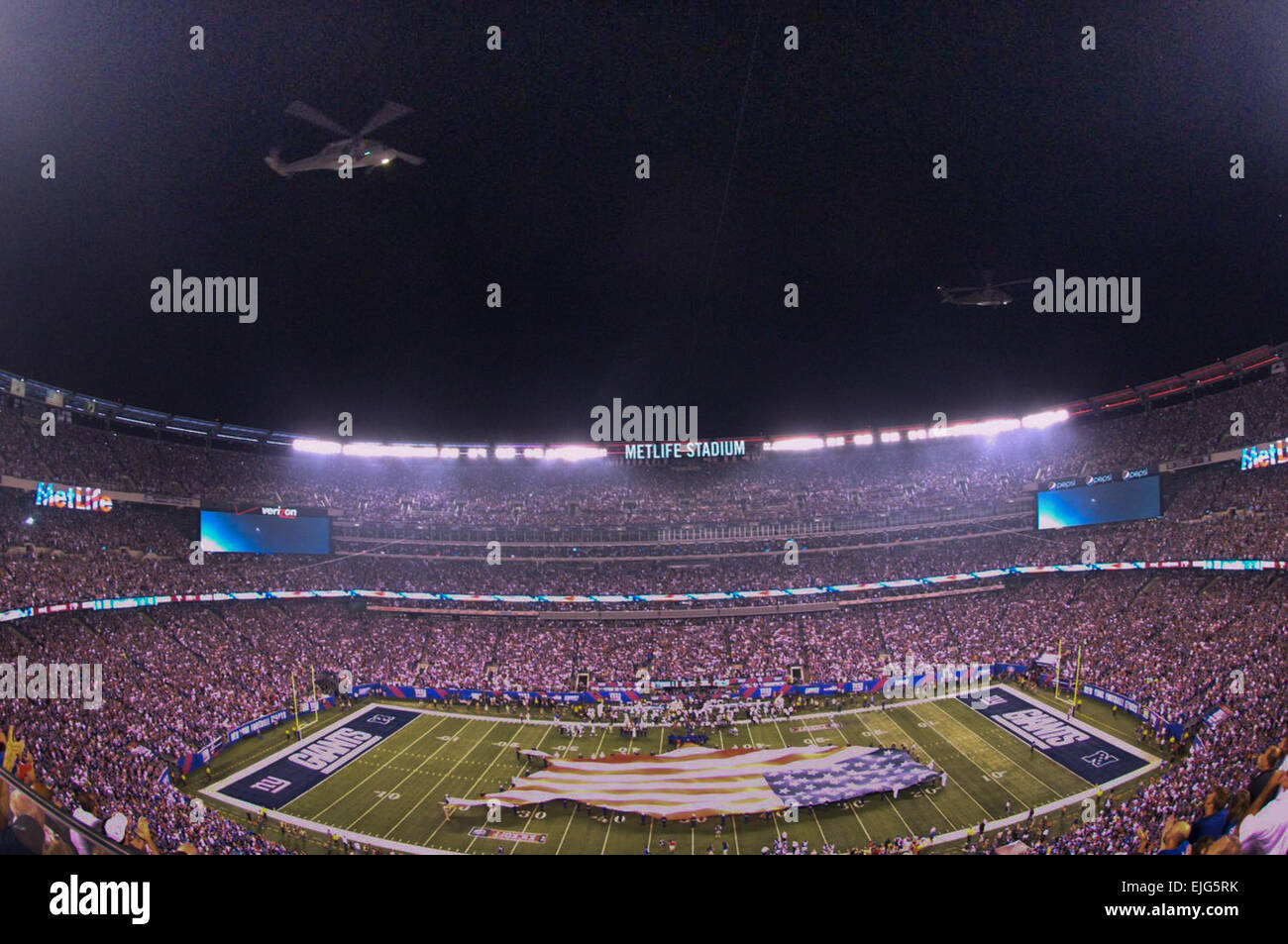 EAST RUTHERFORD, N.J. - Blackhawk Hubschrauber aus New Jersey Air National Guard ausführen eine Überführung, während Soldaten, Marines, Matrosen, Küste Gardisten und Flieger ein U.S.-förmigen amerikanische Flagge über das Feld während der Pre-game Zeremonien für die NFL-Saison Eröffnung Spiel zwischen den New York Giants und die Dallas Cowboys im MetLife Stadium, Sept. 5 angezeigt. Mehr als 60 Mitglieder-Service präsentiert die große Fahne, wie Queen Latifah die Nationalhymne sang. US-Armee John Manley Stockfoto