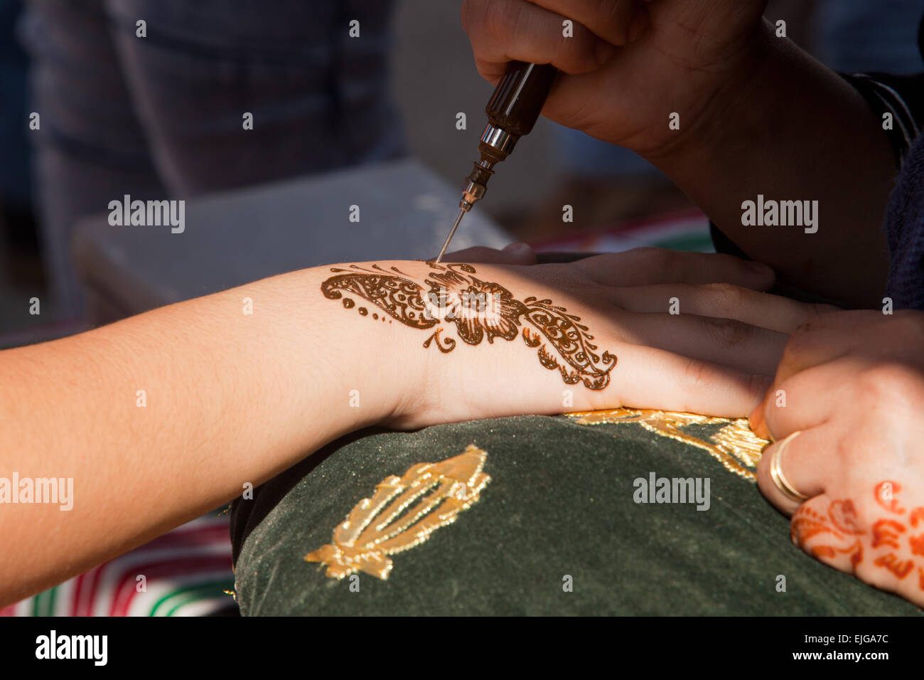 Bildausschnitt von Henna wird angewendet, um grün und gold Gewebekissen übergeben Stockfoto