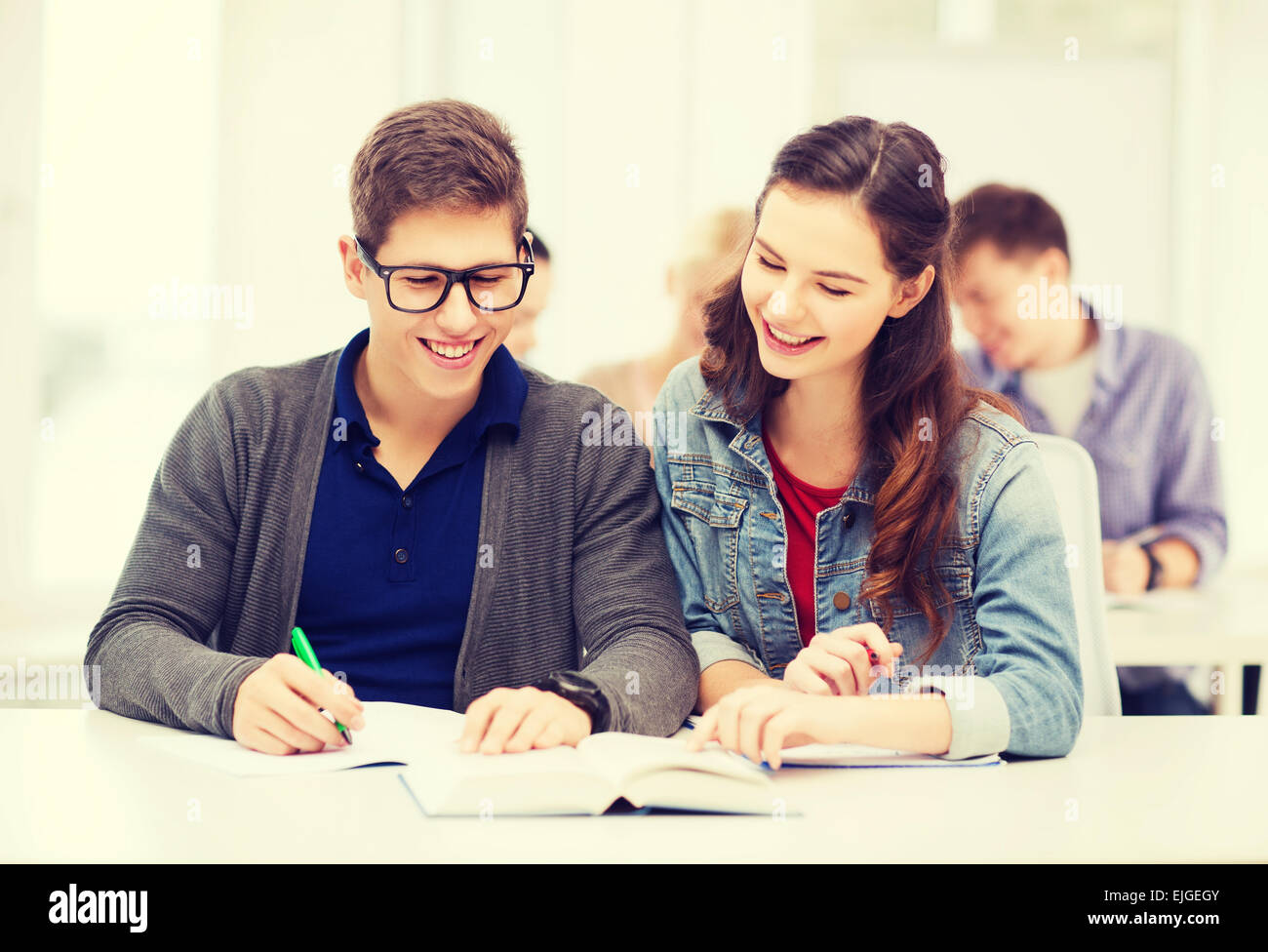 zwei Jugendliche mit Notebooks und Buch in der Schule Stockfotografie ...
