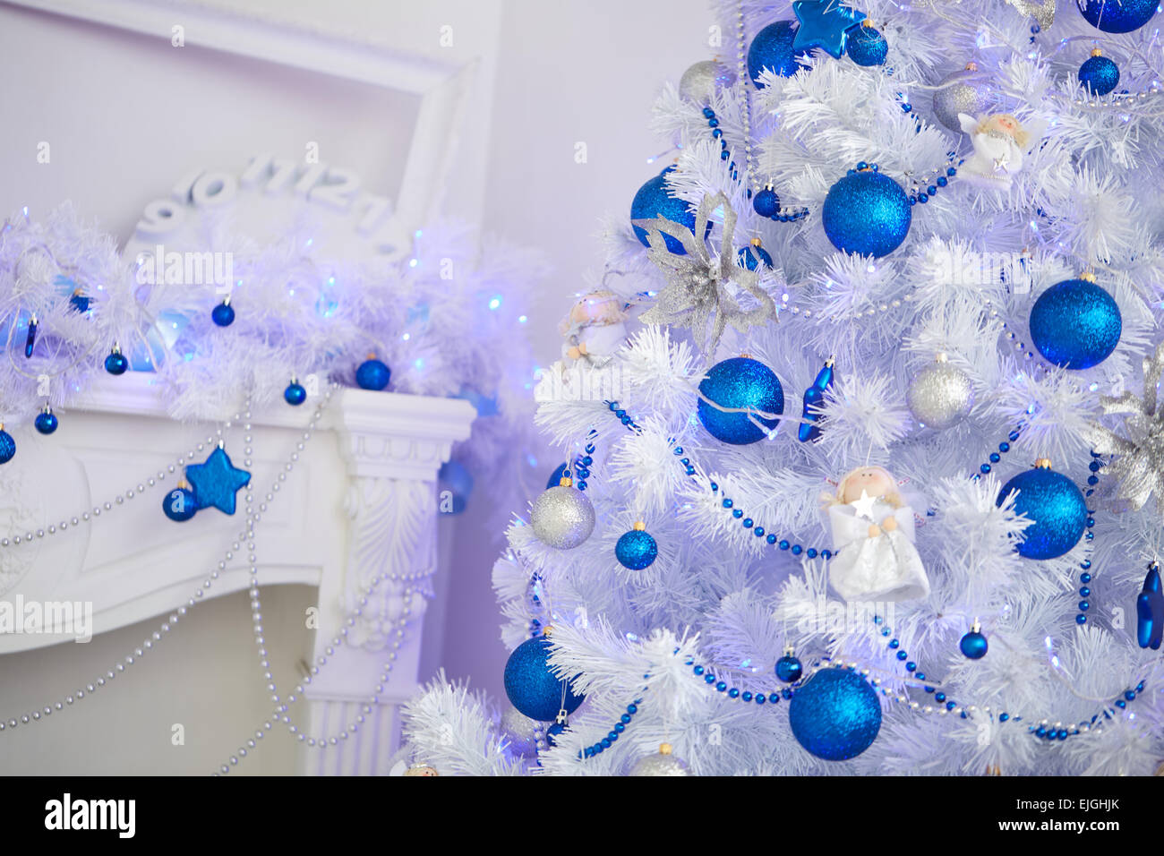 Weihnachtsbaum, Kamin, Uhren, Spielzeug, Geschenke in einem weißen Raum Stockfoto