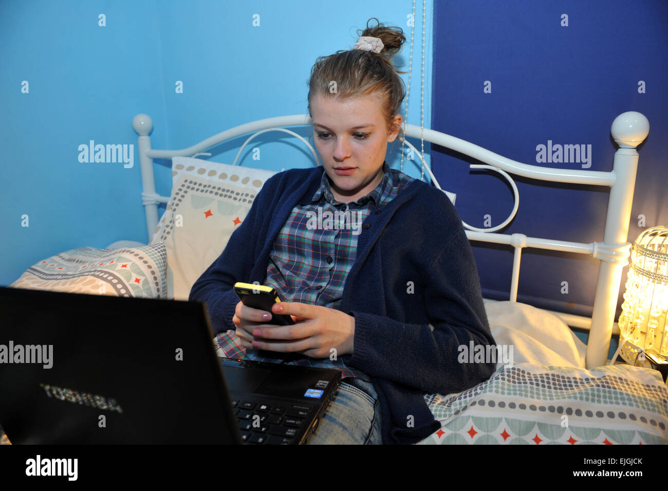 Eine Teenager-Mädchen nutzt ihr Laptop in ihrem Schlafzimmer. MODEL RELEASED Stockfoto