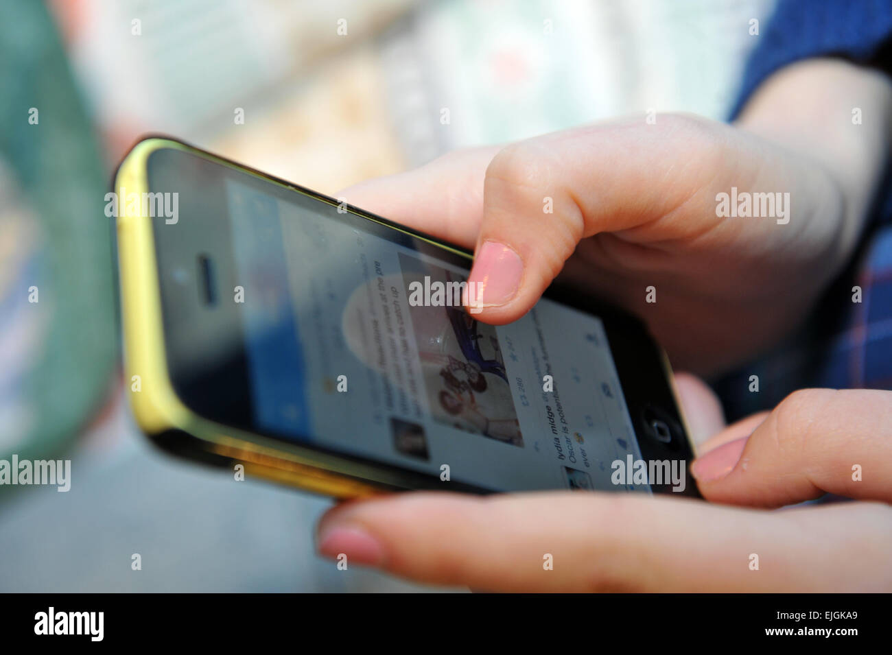 Teenager-Mädchen surft im Web auf ihrem mobile Iphone UK Stockfoto