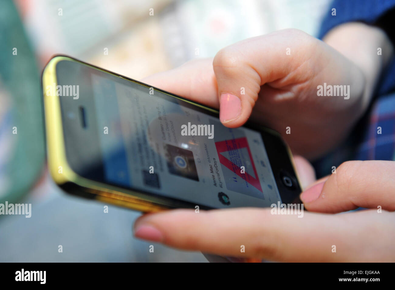 Teenager-Mädchen surft im Web auf ihrem mobile Iphone UK Stockfoto