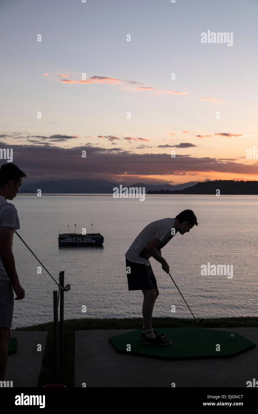 Ein junger Mann versucht das Loch in eine Herausforderung in Taupo, Neuseeland. Stockfoto