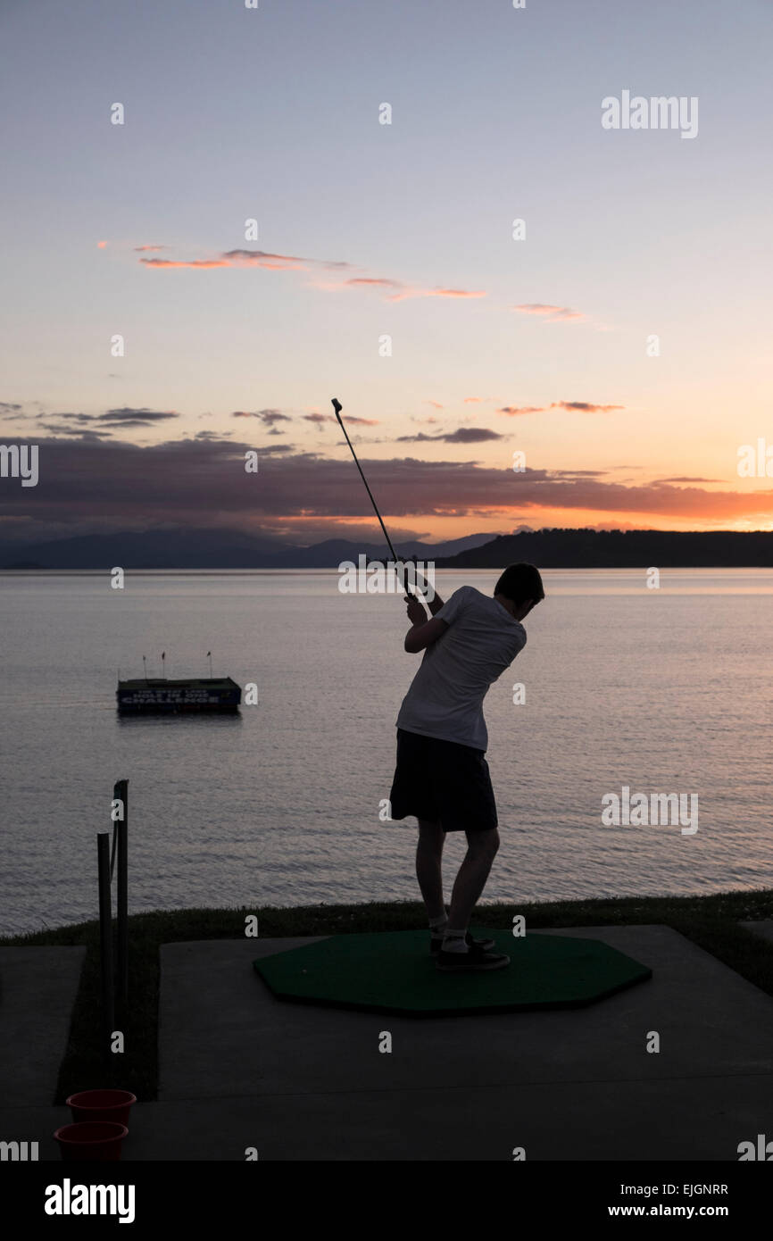 Ein junger Mann versucht das Loch in eine Herausforderung in Taupo, Neuseeland. Stockfoto