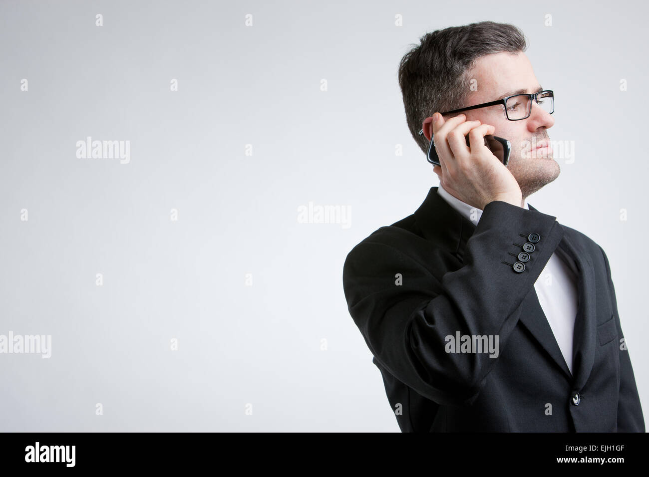Geschäftsmann mit einem Handy telefonieren und auf der Suche an anderer Stelle aber im Bereich COPY SPACE Stockfoto