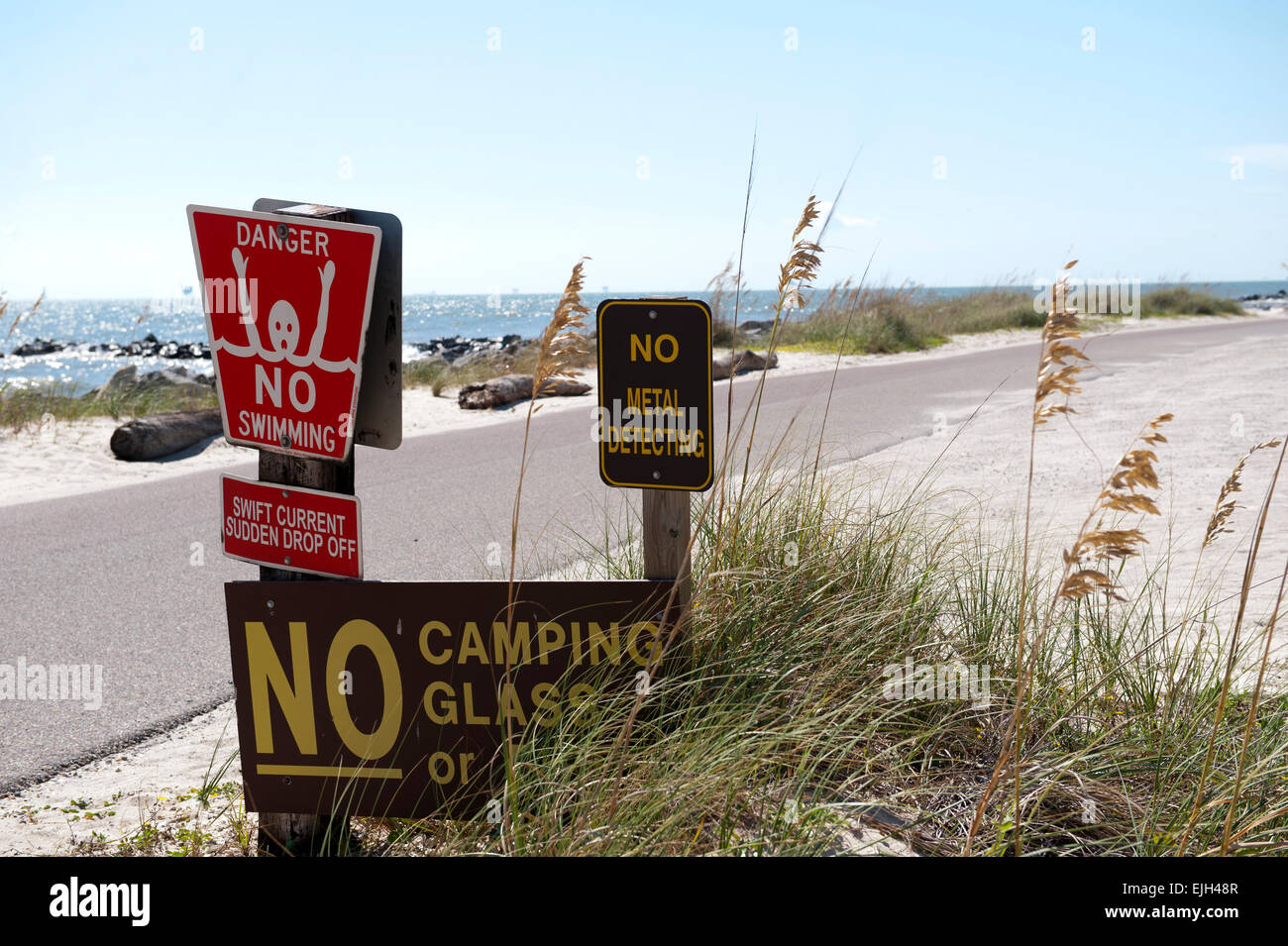 Gefahr-Schildern am Straßenrand an der Uferlinie auf Dauphin Island, Alabama Stockfoto