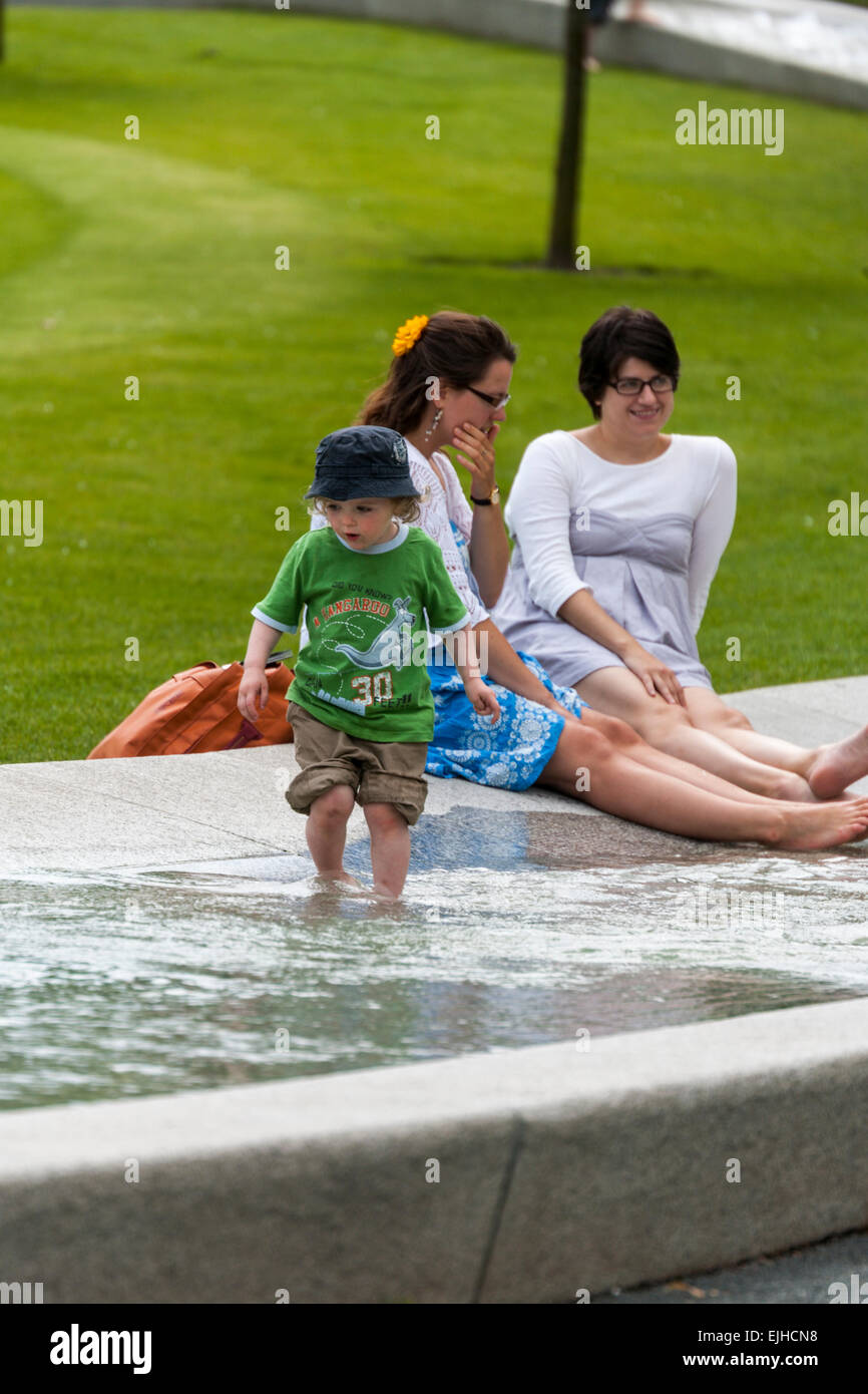Zwei Frauen und ein Kind genießen Sie das Wasser an Prinzessin Diana Memorial Fountain im Hyde Park, London, England Stockfoto