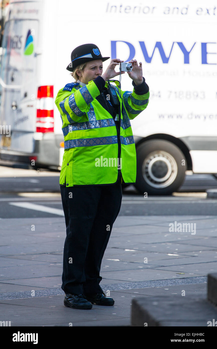 Polizistin nehmen Foto mit Punkt und schießen, London, England Stockfoto