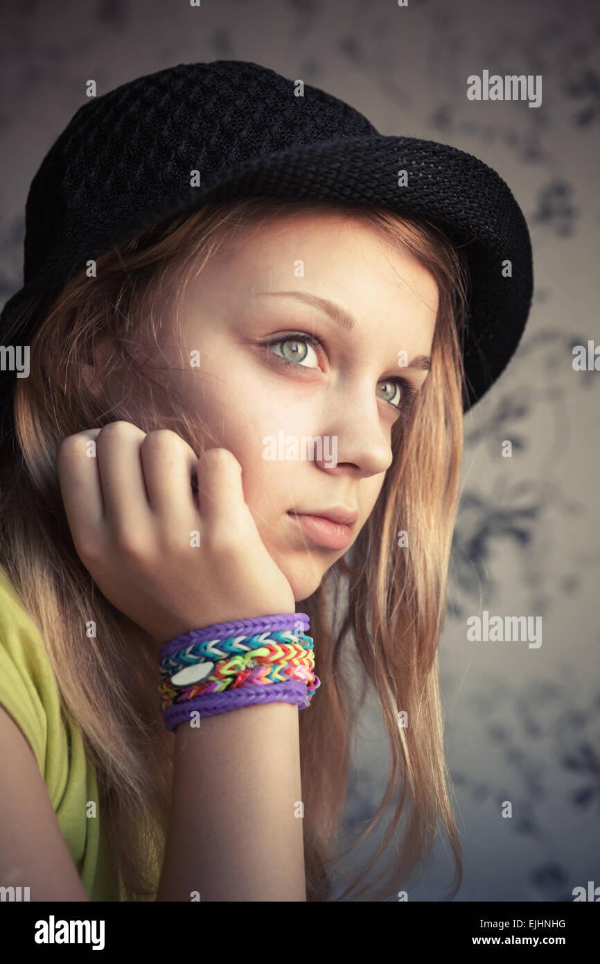 Porträt von schöne blonde Teenager-Mädchen in schwarzen Hut und GummiBracelets Webstuhl, getönten Vintage Foto, Instagram-Stil-Effekt Stockfoto