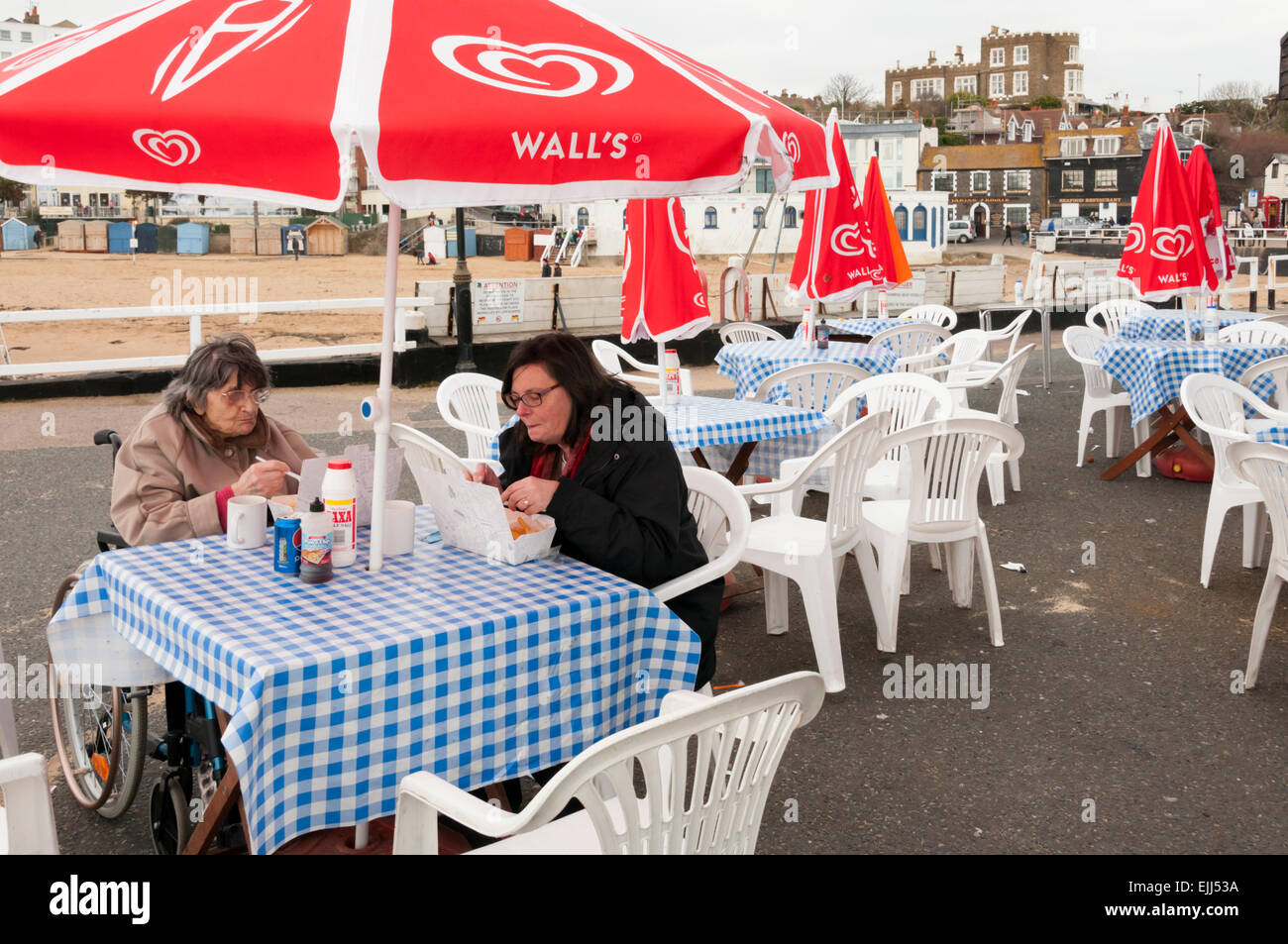 Aktive alte Dame in Ihren 90er Jahren essen Fisch & Chips mit ihrer Tochter auf Broadstairs Harbour Jetty. MODEL RELEASED. Stockfoto