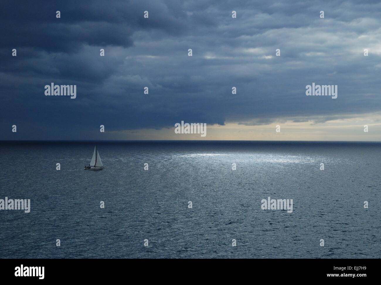 Segelyacht unter einem dramatischen dunklen stürmischen Himmel über dem Atlantik, Gran Canaria, Kanarische Inseln, Spanien. Stockfoto