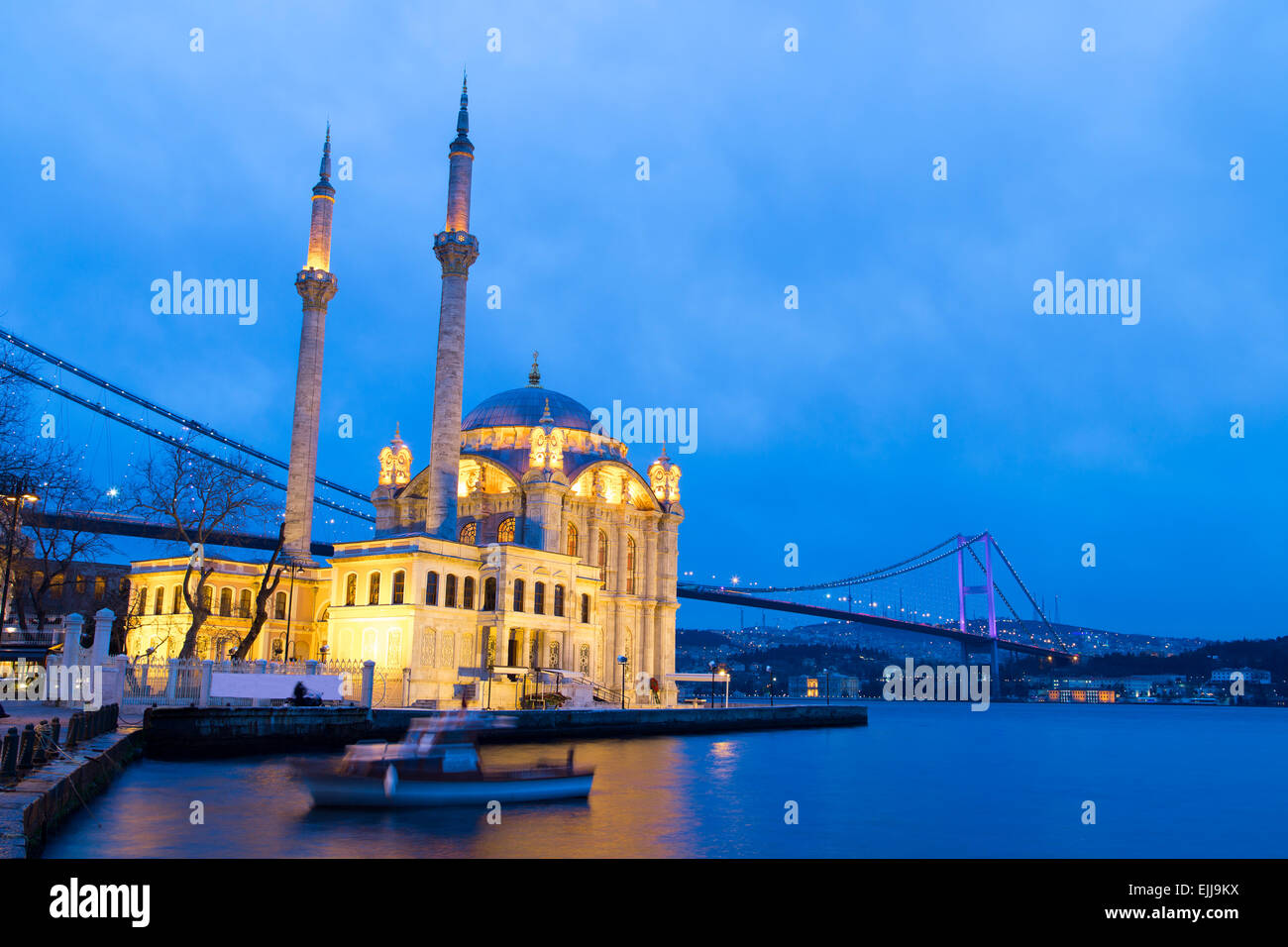 Bunte Ortakoy-Moschee und Reflexion der Bosporus-Brücke am Meer am Abend. Blaue Stunden in Küstennähe Bosporus in Istanbul Stockfoto