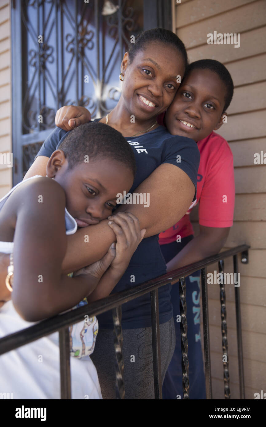 Porträt der Mutter und zwei Söhne auf ihrer Veranda in Brooklyn, New York. Stockfoto