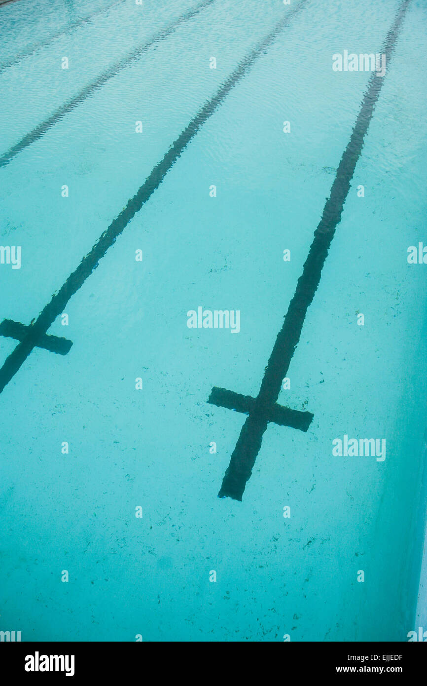 Fahrbahnmarkierungen unter Wasser in einem menschenleeren Schwimmbad. Stockfoto