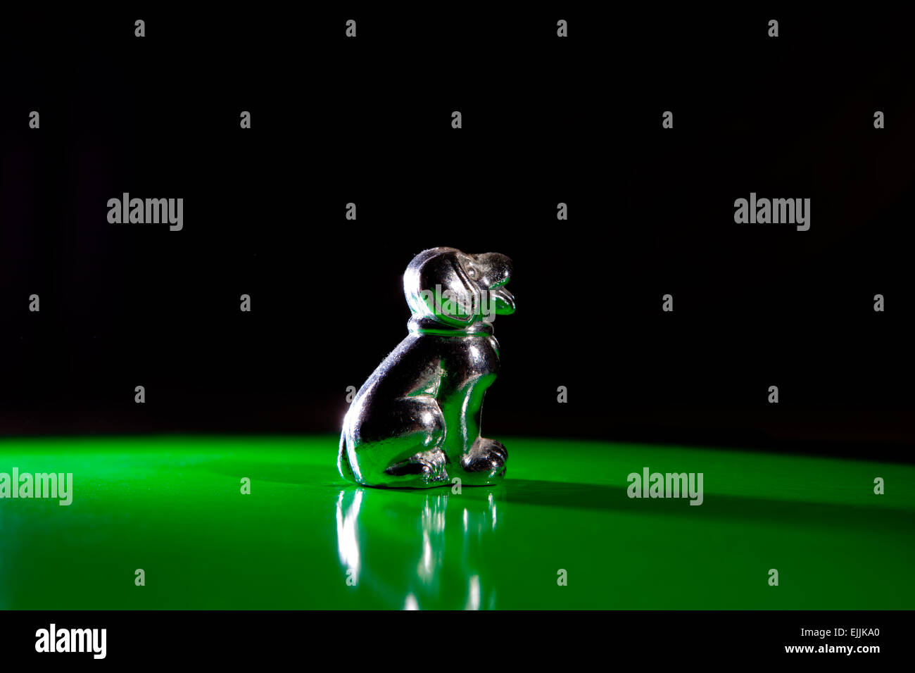 Silberne kleine Dog Figur isoliert auf grünem Hintergrund Stockfoto