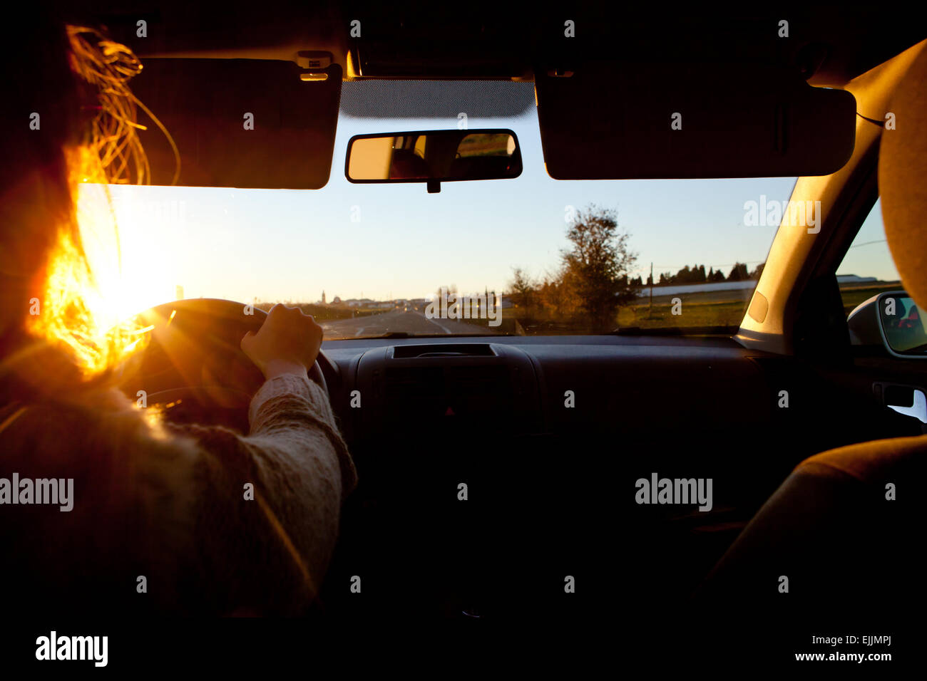 Eine Autofahrerin bei Sonnenuntergang. Probleme der Vision in diesem Tag Stunde Stockfoto