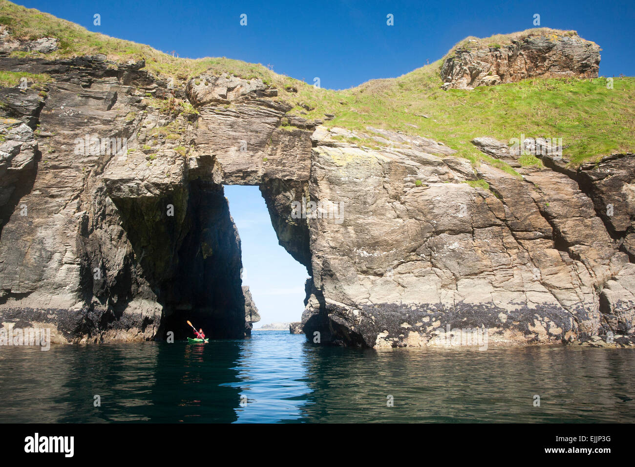 Kajakfahrer Meer durch ein Felsbogen in der Nähe von Hafen, County Donegal, Irland. Stockfoto