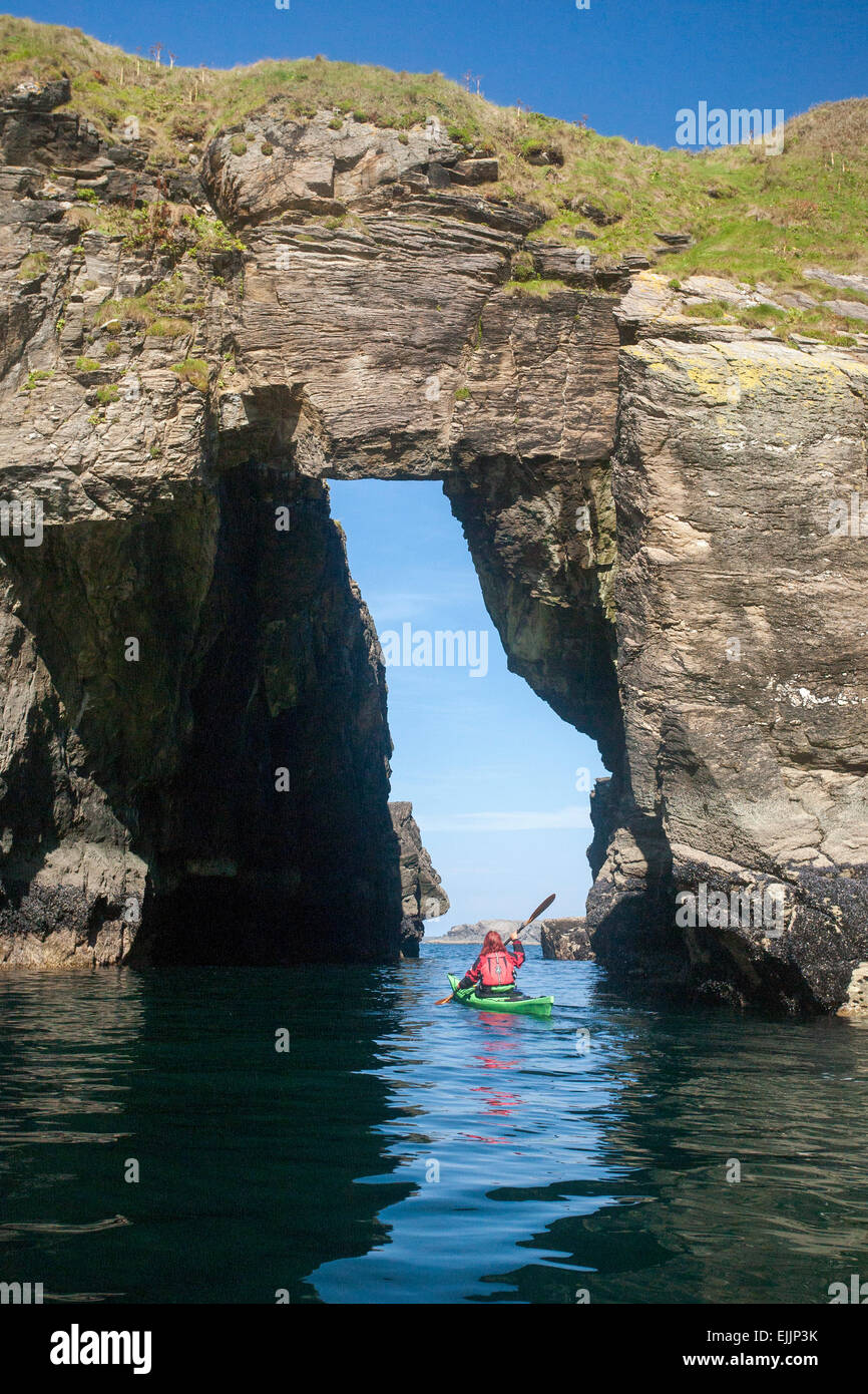 Kajakfahrer Meer durch ein Felsbogen in der Nähe von Hafen, County Donegal, Irland. Stockfoto
