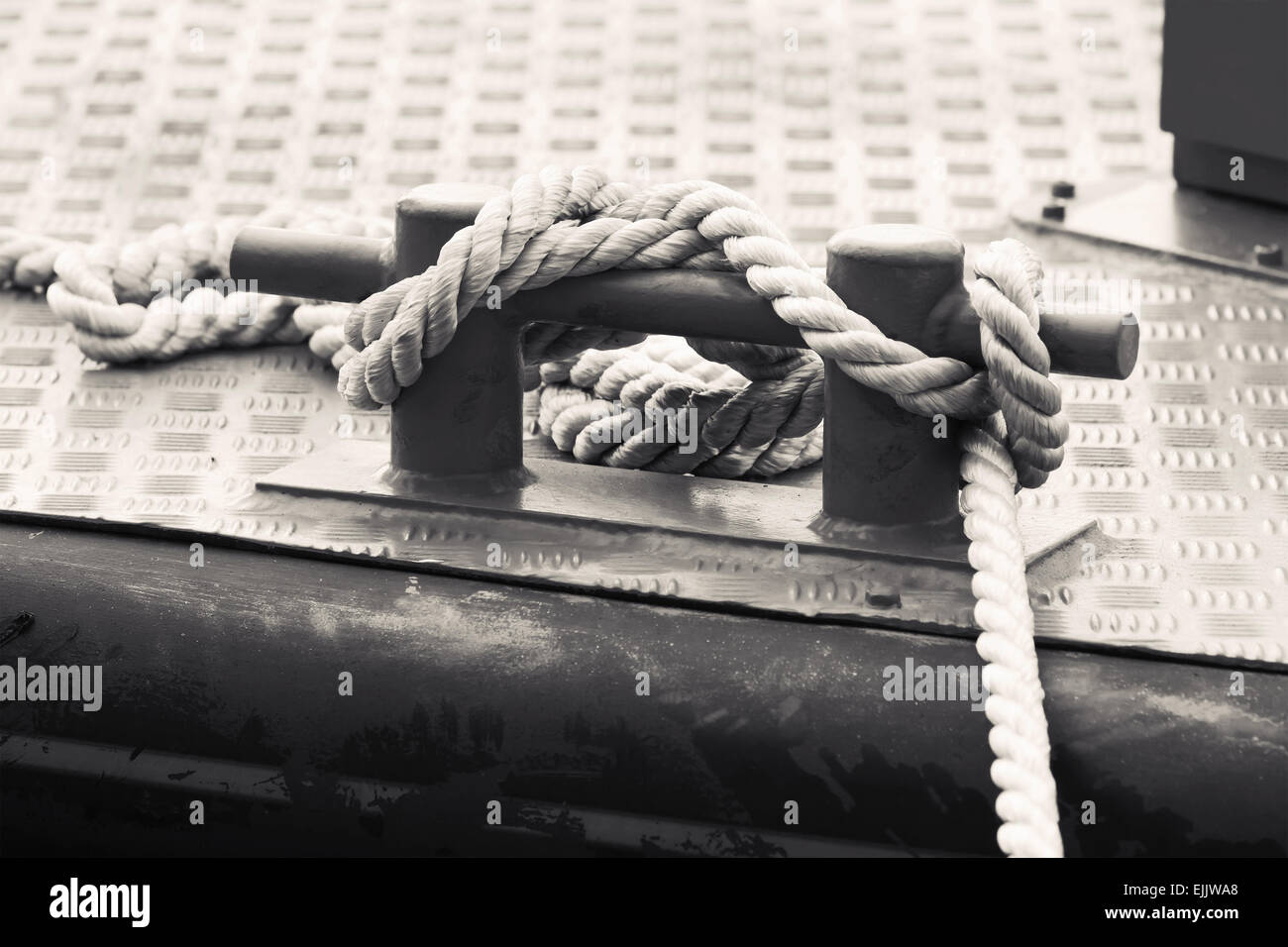 Schwarzer Stahl Poller mit Seilen befestigt auf dem Schiffsdeck eines, monochrome Foto Stockfoto