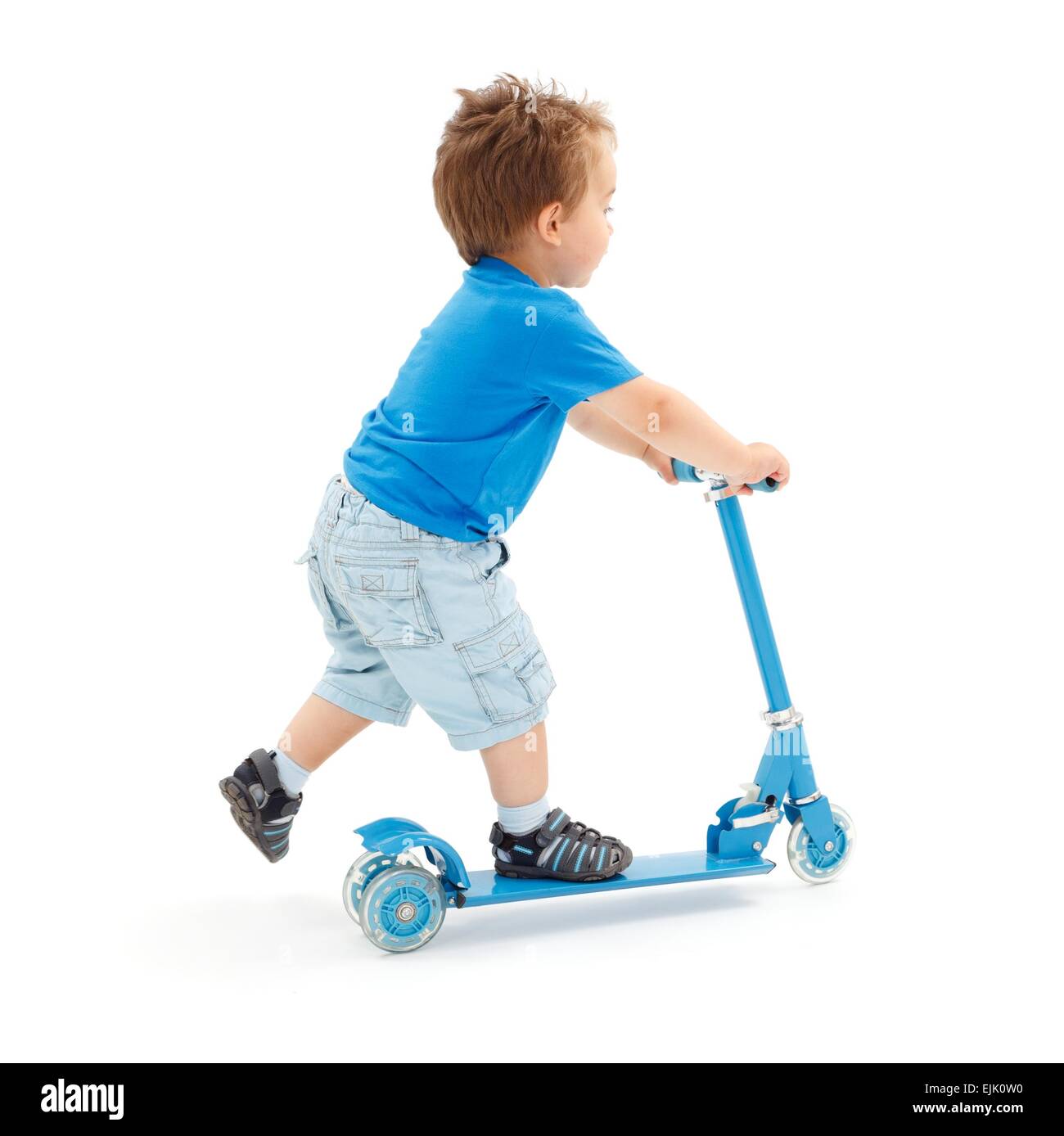 Kleiner Junge geht schnell mit Spielzeug Roller (teilweise Bewegungsunschärfe auf Bein) Stockfoto