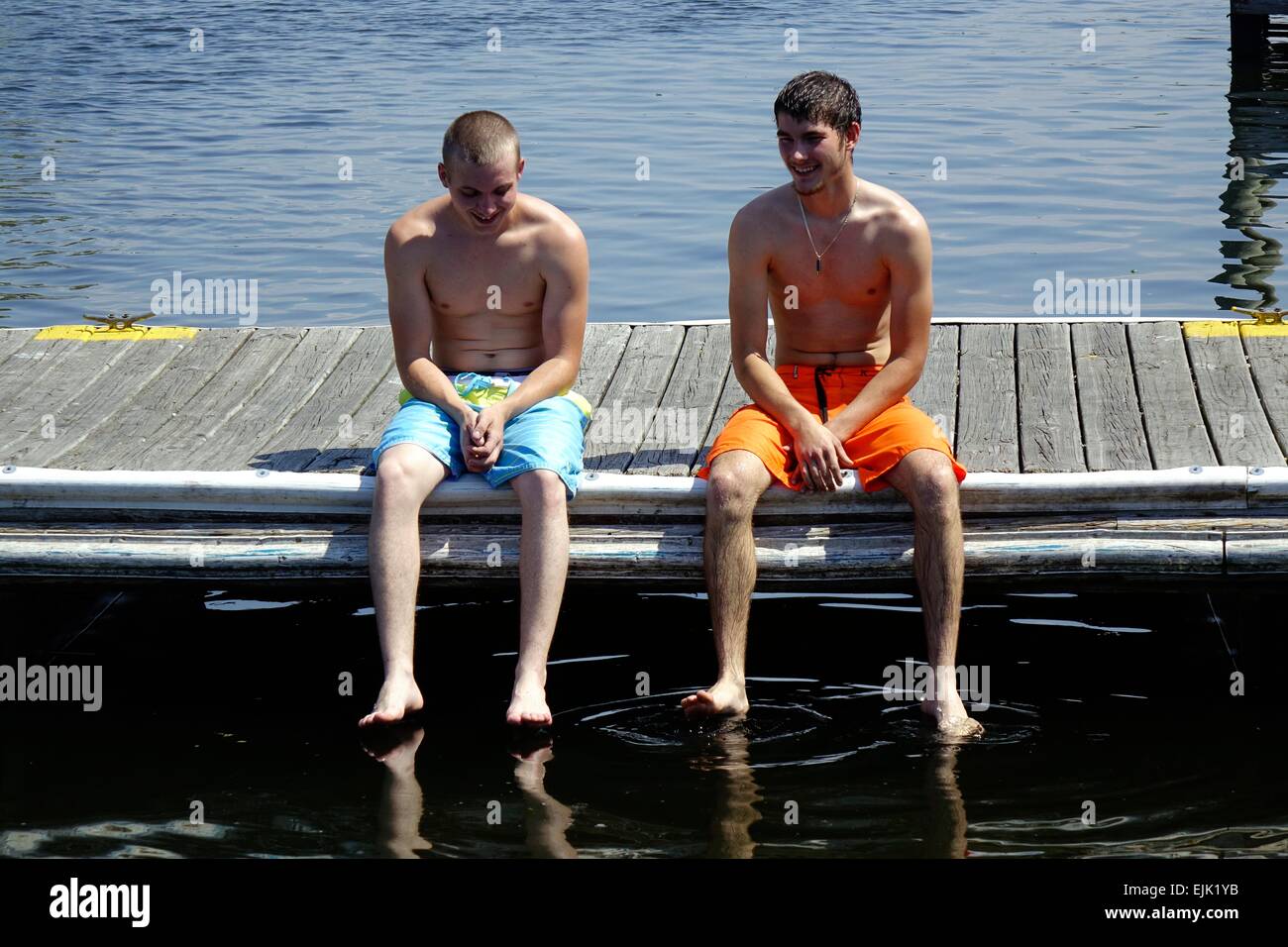 Jungs in Badeanzügen sitzt auf einem Dock in Homosassa, Florida Stockfoto