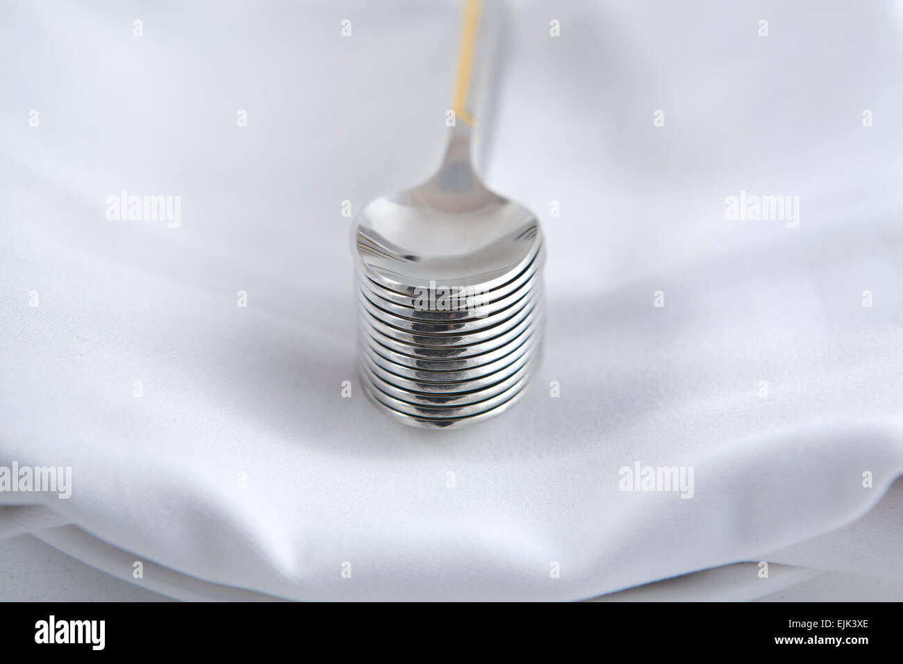 Dessertlöffel über eine weiße Serviette in einem Teller Stockfoto
