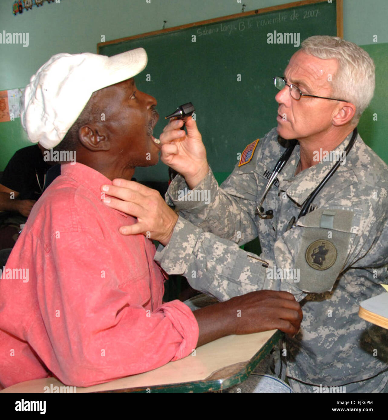 EL LIMONAL, Dominikanische Republik – Army Lt. Colonel Dr. Michael Hoilien, assistiert von Air Force Staff Sgt Luis Santa, untersucht die Kehle eines Dominikanischen Mannes in einer Klinik Einrichten von US Servicemembers aus Joint Task Force-Bravo 10 November. Die beiden waren Teil eines Expeditionary Medical Liaison Teams eingesetzt in die Dominikanische Republik, den Inselstaat medizinische Hilfe anzubieten.  Juan Torres Stockfoto