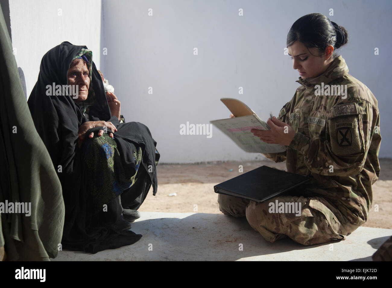 US Armee Sgt. Lidya Admounabdfany schreibt Informationen von einer Frau die Frau Center in der Nähe von Zhari Bezirk Mitte außerhalb der Forward Operating Base Pasab, Provinz Kandahar, Afghanistan, 17. Dezember 2011. Admounabdfany ist ein Mitglied der 3. Brigade, 10th Mountain Division weibliche Engagement-Team und sammelt Informationen von den Frauen der FET decken und Winterkleidung für die Frauen und ihre Familien verteilen kann. Stockfoto